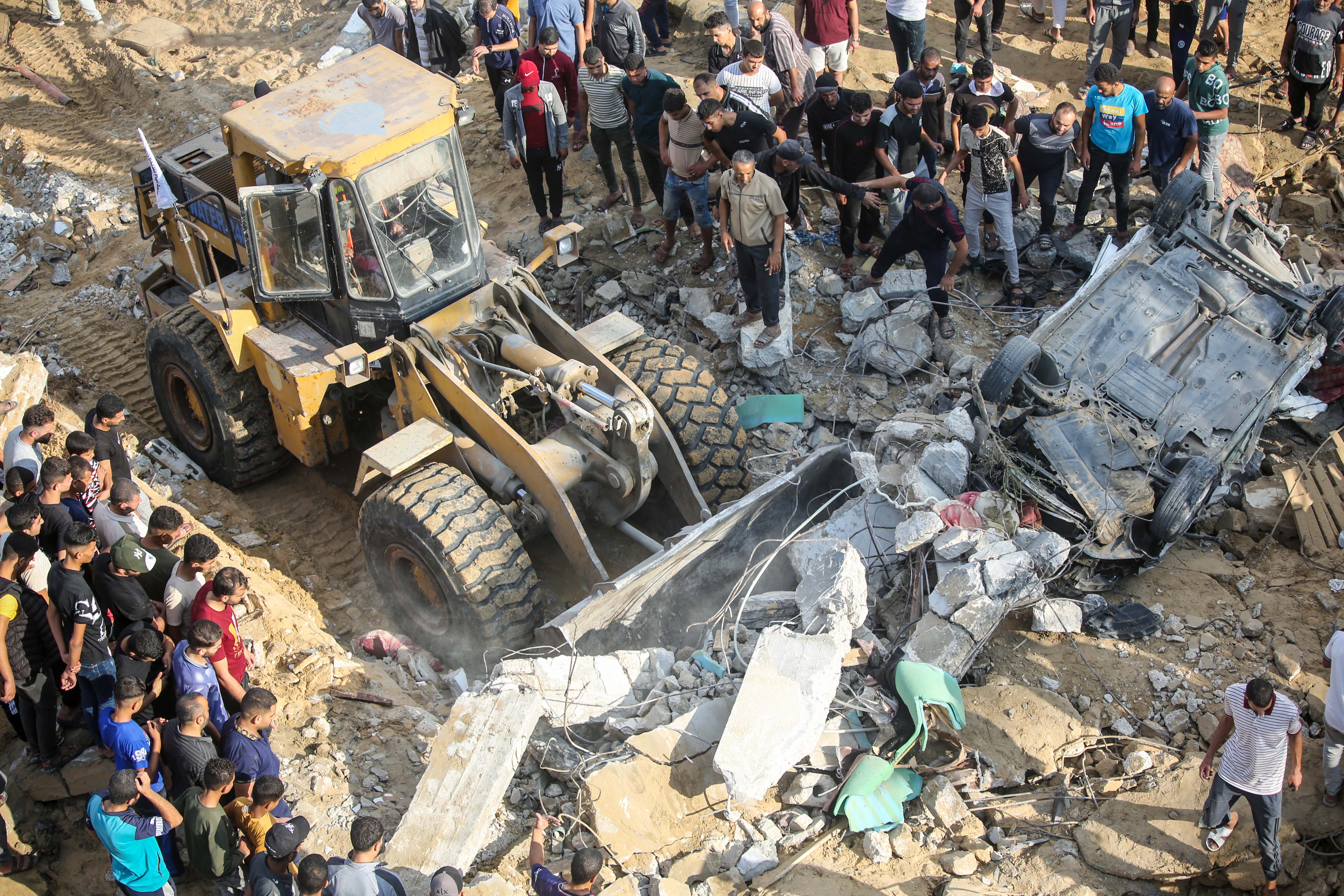 Palestinian citizens inspect what remains of their home, which was destroyed during Israeli raids on the southern Gaza Strip