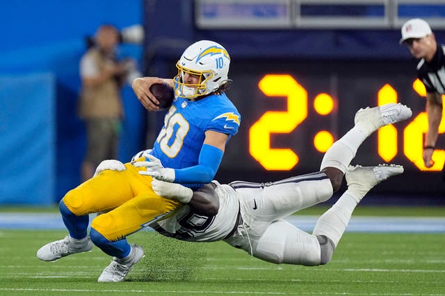 Los Angeles Chargers quarterback Justin Herbert (10) is tackled by Dallas Cowboys defensive end DeMarcus Lawrence (90) during the fourth quarter (Mark J Terrill/AP)