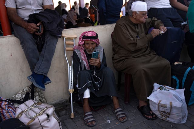 <p>Palestinians wait to cross into Egypt at the Rafah border crossing in the Gaza Strip</p>