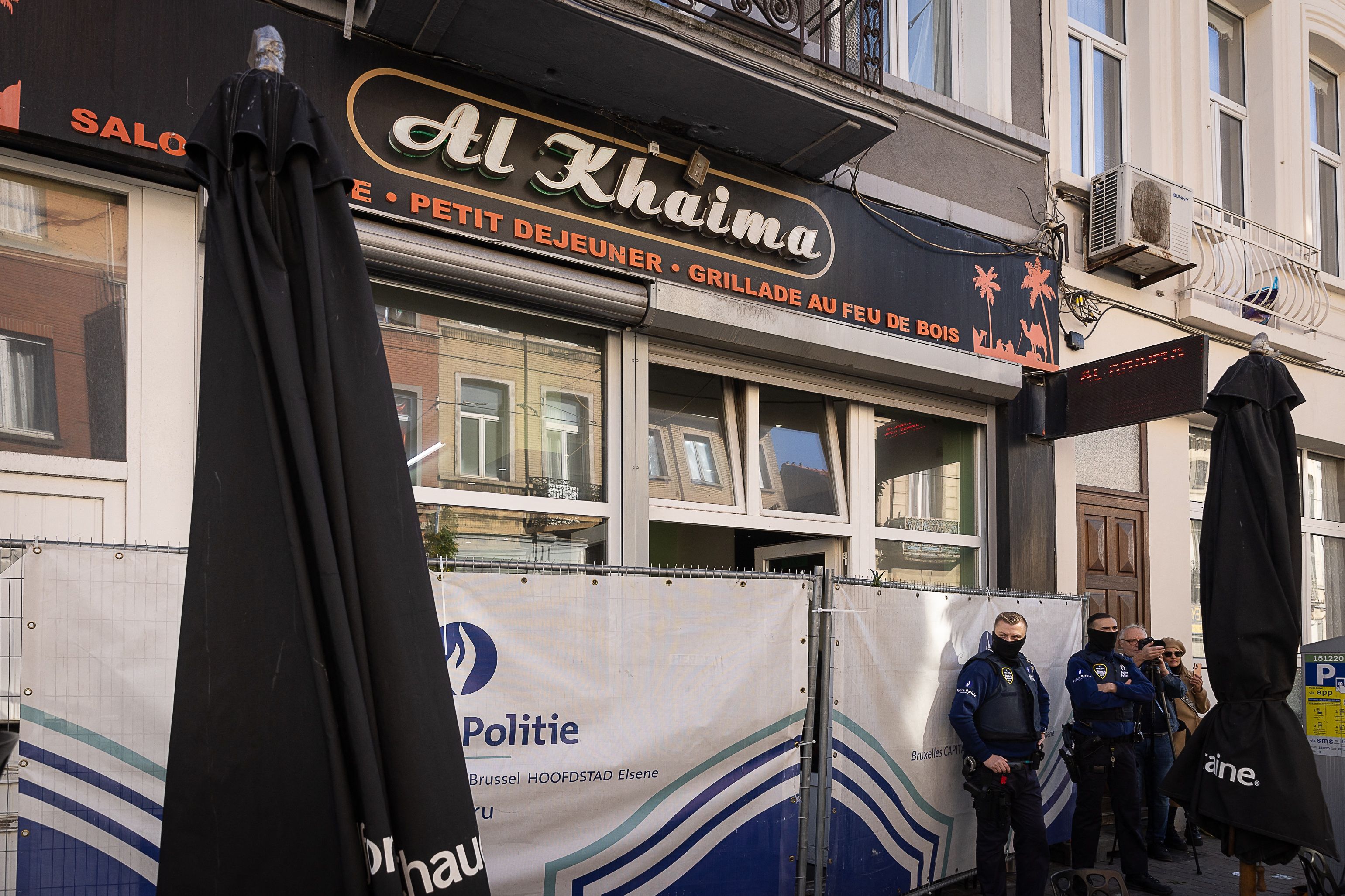 Belgian police officers stand outside cafe Al Khaima in the Schaerbeek area of Brussels