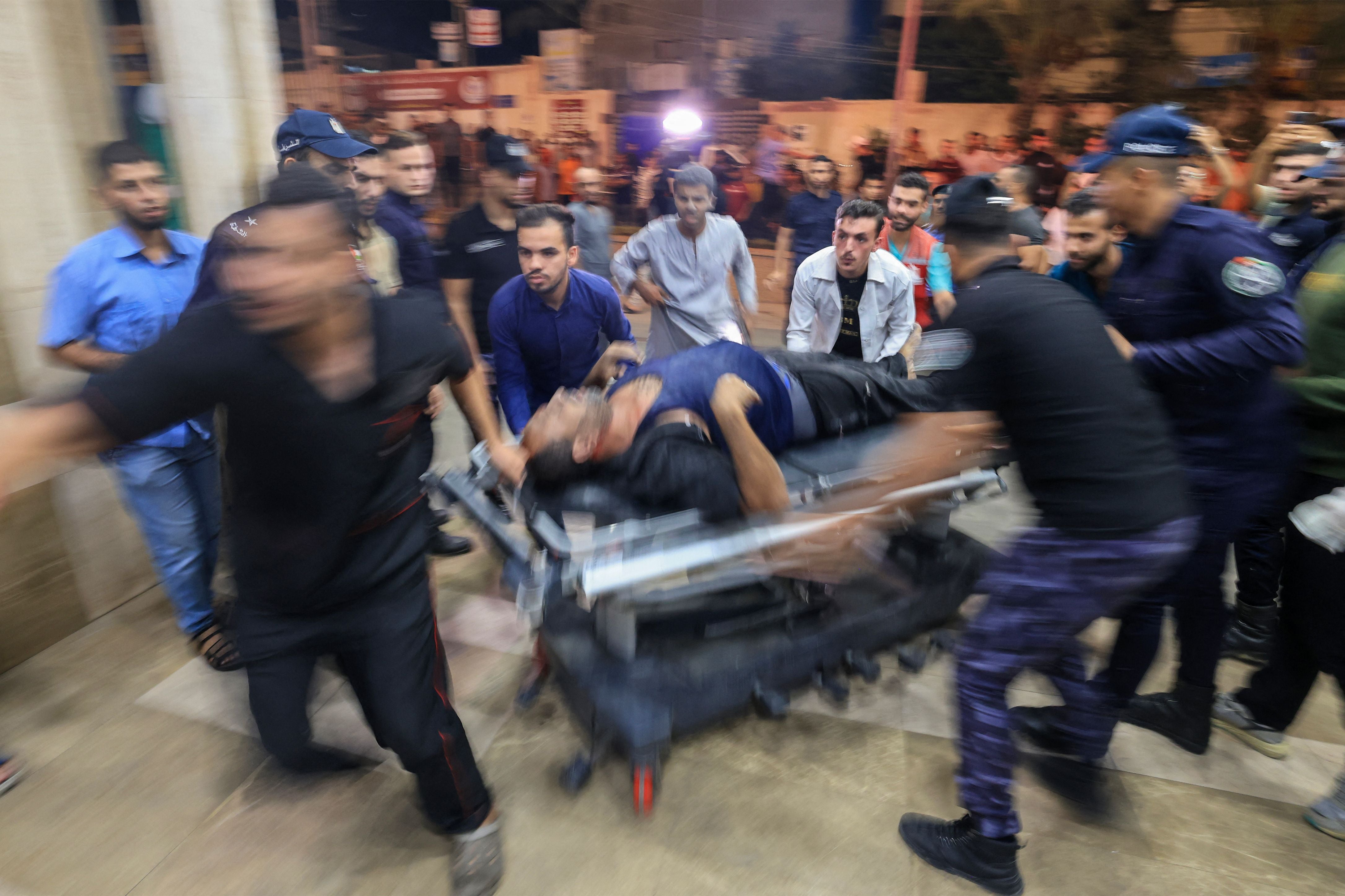 A Palestinian man injured in an Israeli air strike is wheeled inside the Nasser hospital in Khan Yunis