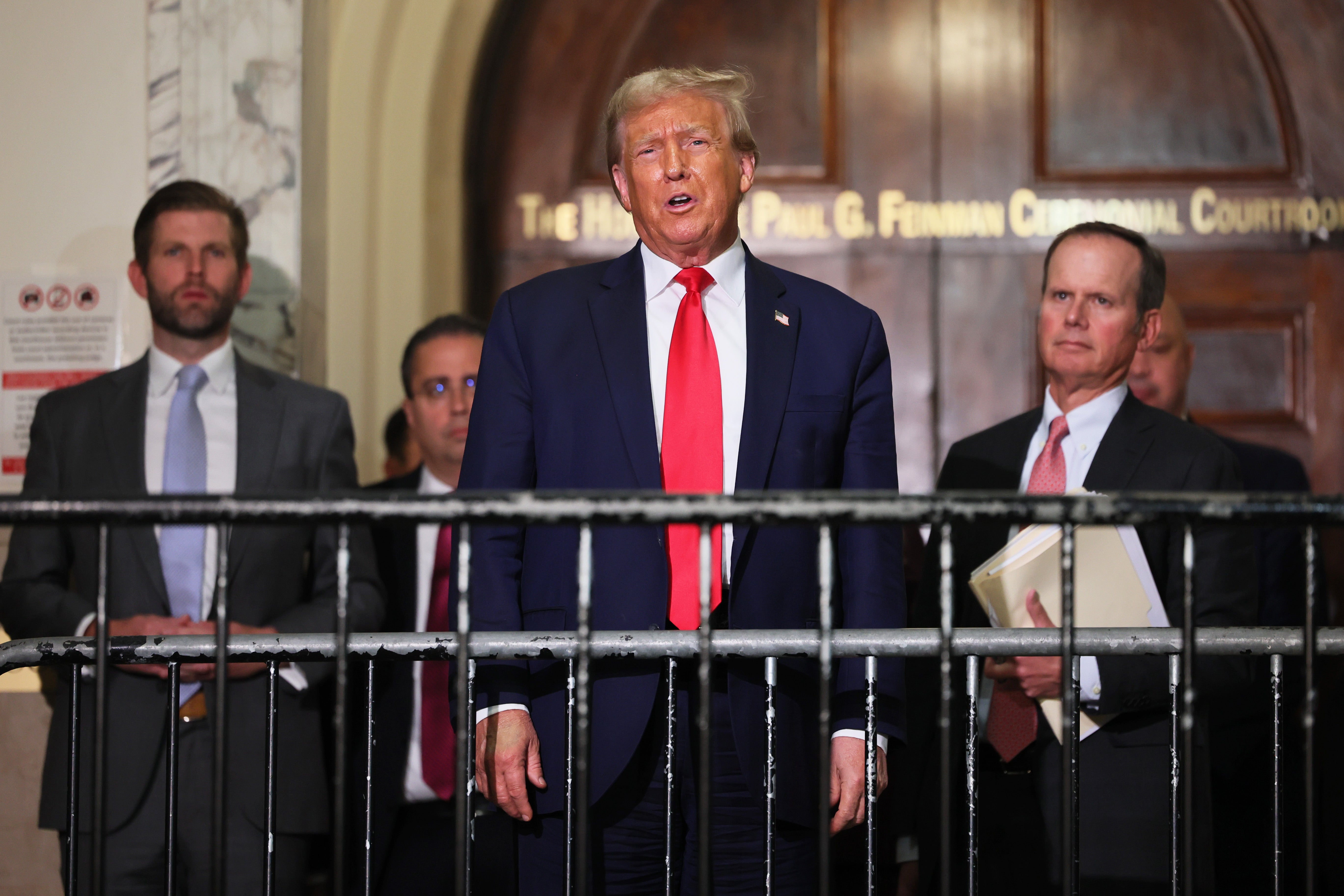 Donald Trump and his legal team, along with his son Eric Trump, left, address reporters during a lunch break in a civil trial on fraud allegations in Manhattan on 17 October.