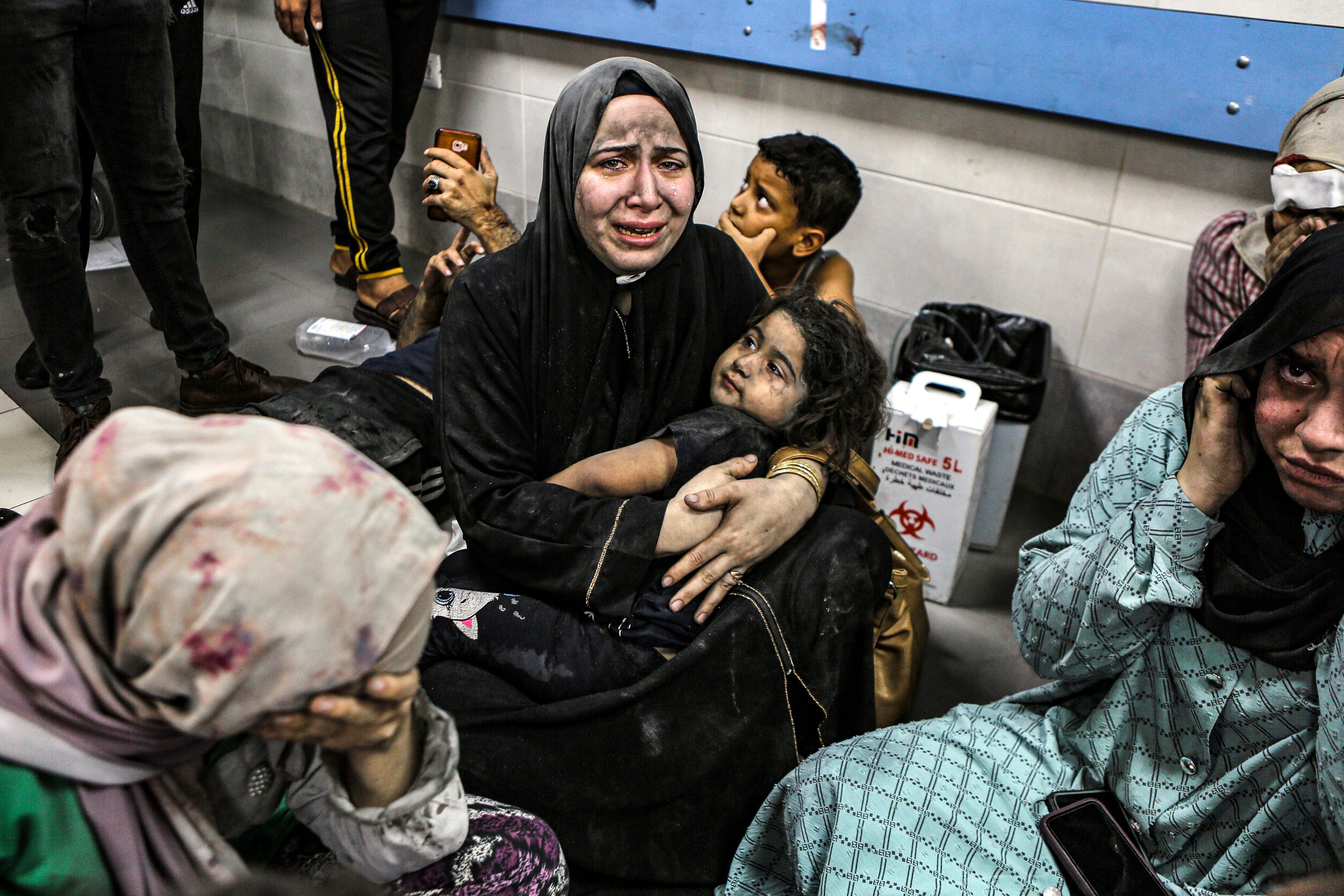 Wounded Palestinians sit in al-Shifa hospital in Gaza City, central Gaza Strip, after arriving from al-Ahli hospital