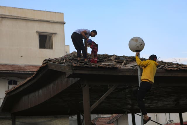 Palestinians inspect the damage at al Ahli hospital, in Gaza City, on Wednesday (Abed Khaled/AP)