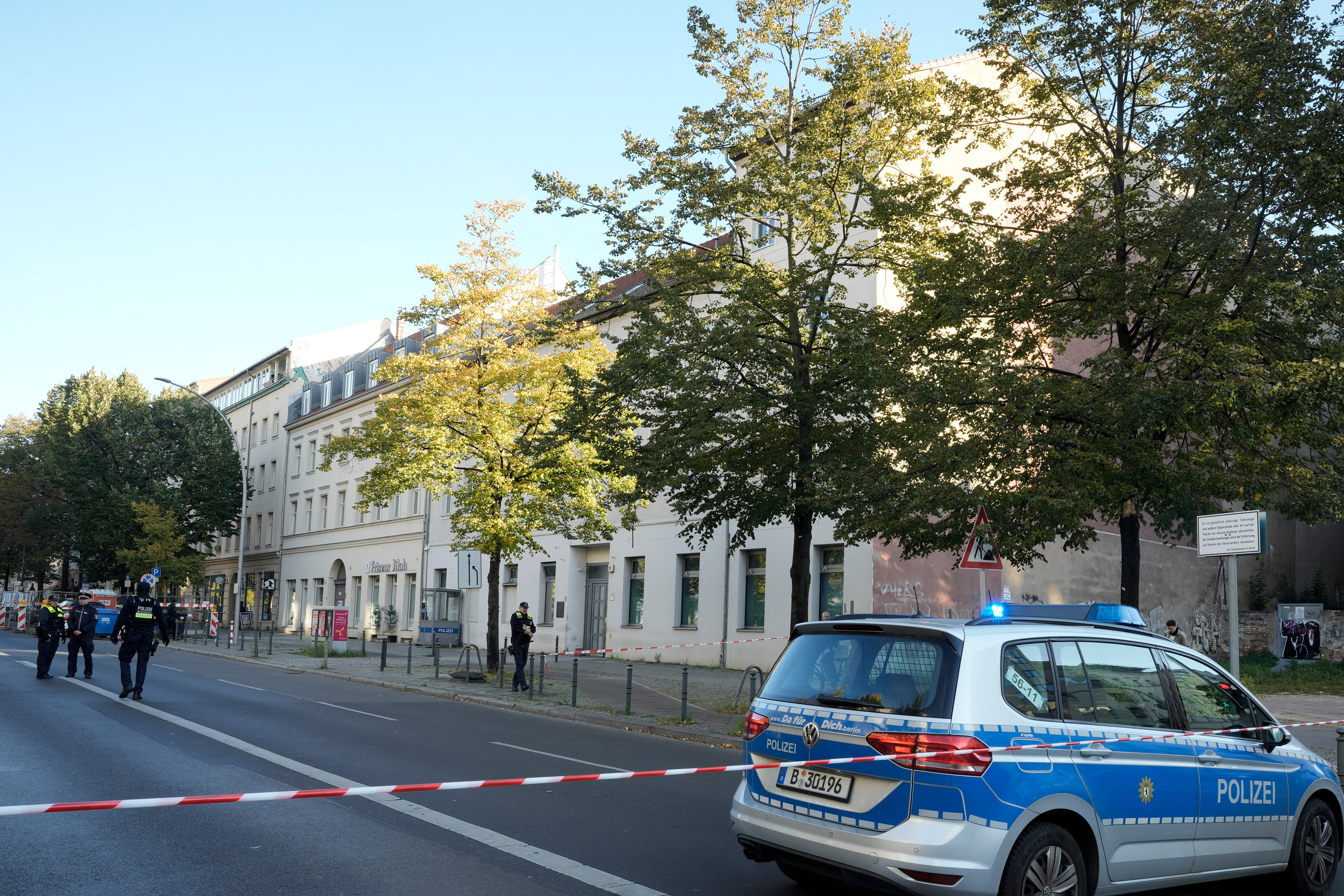 <p>German police officers stand guard in front of the building complex, center, of the Kahal Adass Jisroel community</p>