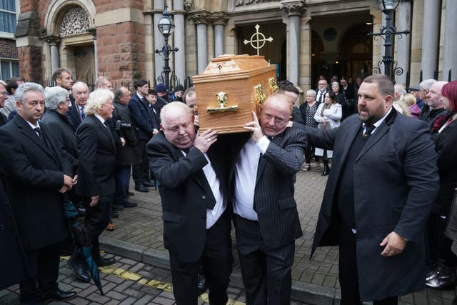 Photographers and members of the media make a Guard of Honour as the coffin of Olympic medallist boxer and press photographer Hugh Russell is taken from St Patrick’s Church in Belfast (Brian Lawless/PA)