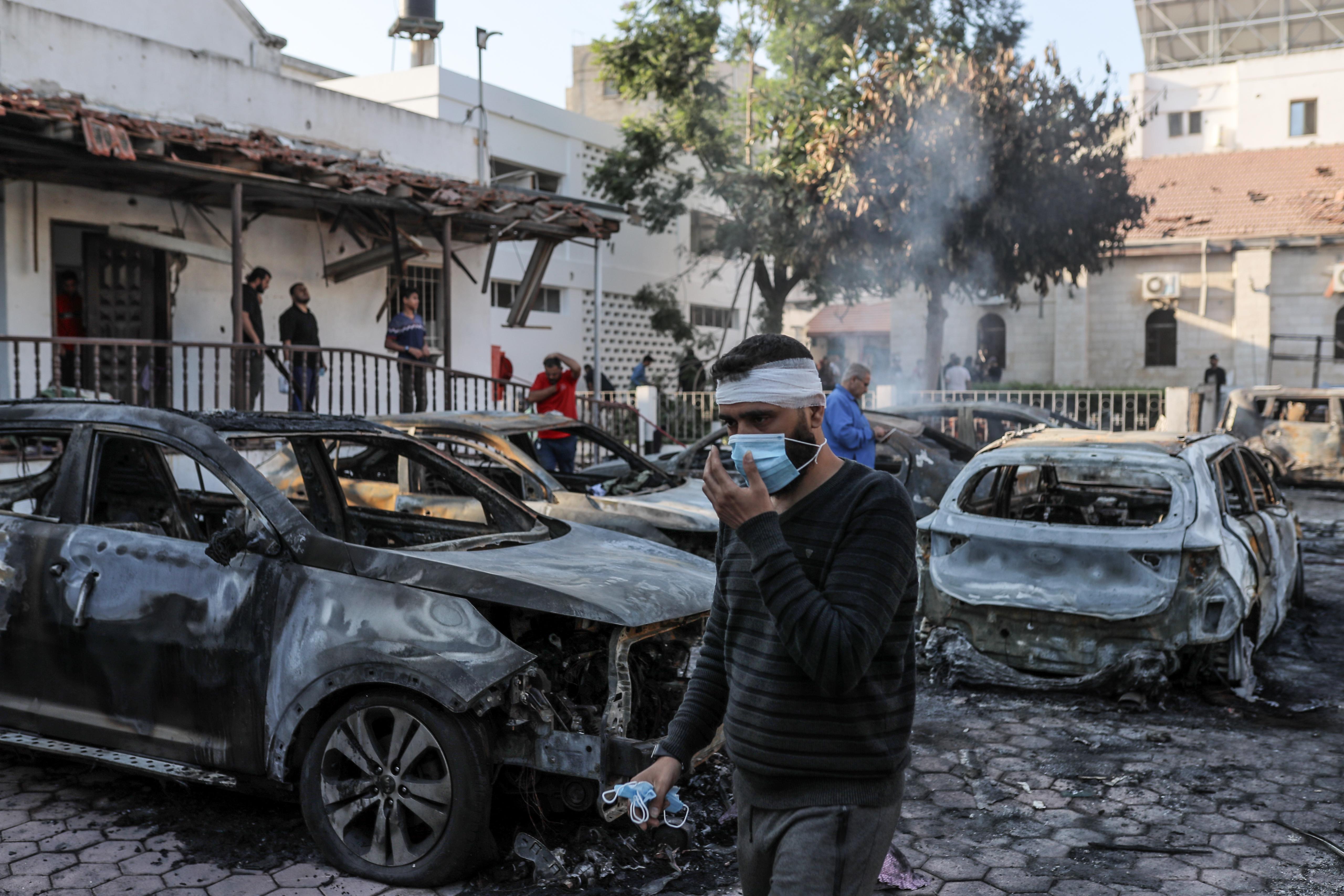 Wrecked vehicles smoulder after al-Ahli Baptist Hospital was hit in Gaza City