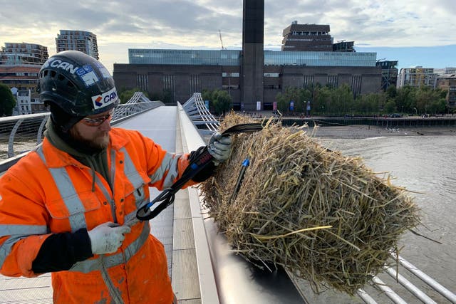 A bundle of straw is hung from London’s Millennium Bridge (City Bridge Foundation)