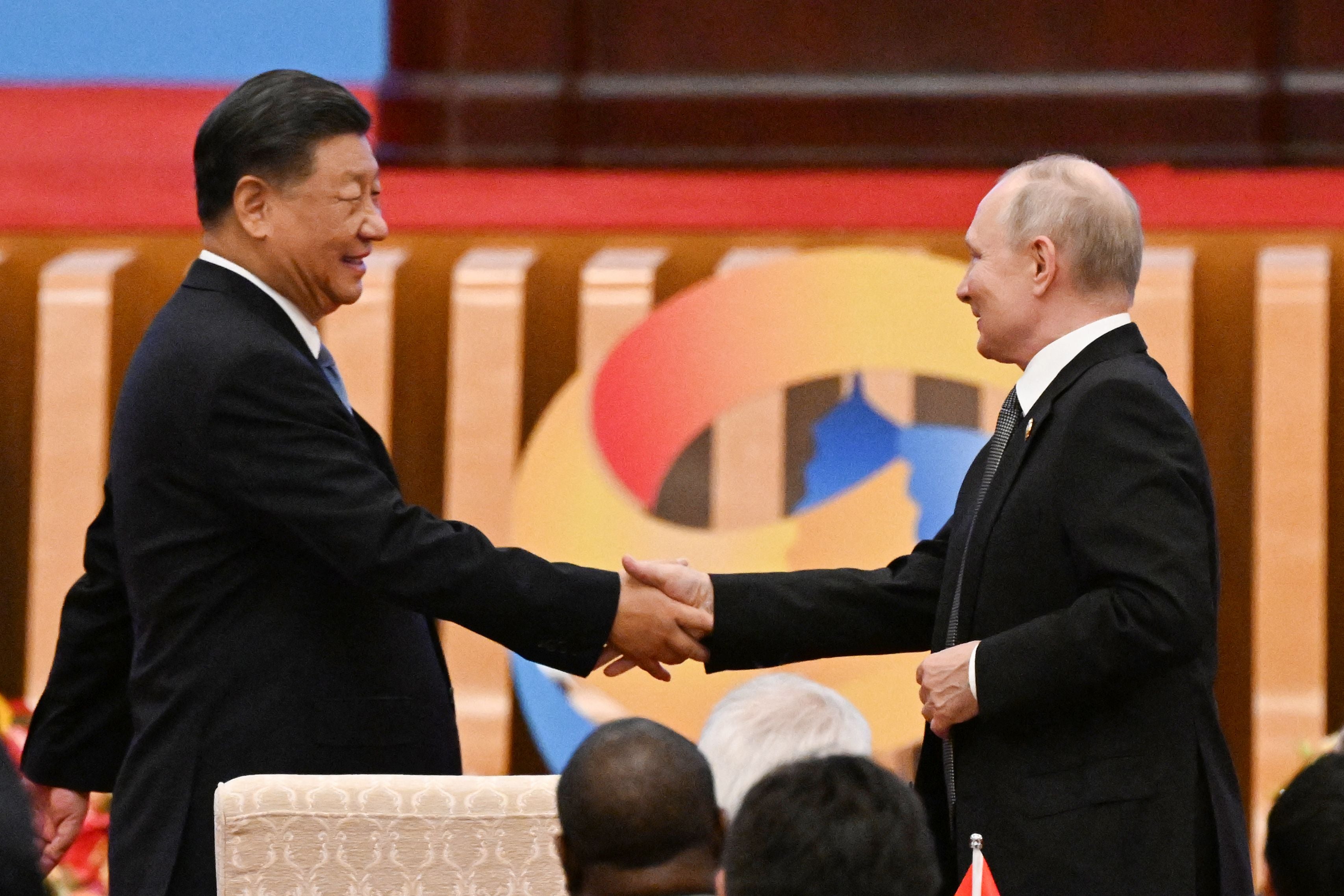 Xi Jinping shakes hands with Vladimir Putin at the Belt and Road summit in the Great Hall of the People in Beijing