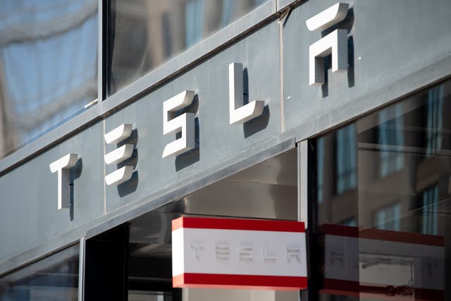 <p>This file photo shows the Tesla logo is seen outside of their showroom in Washington, DC, on August 8, 2018</p>