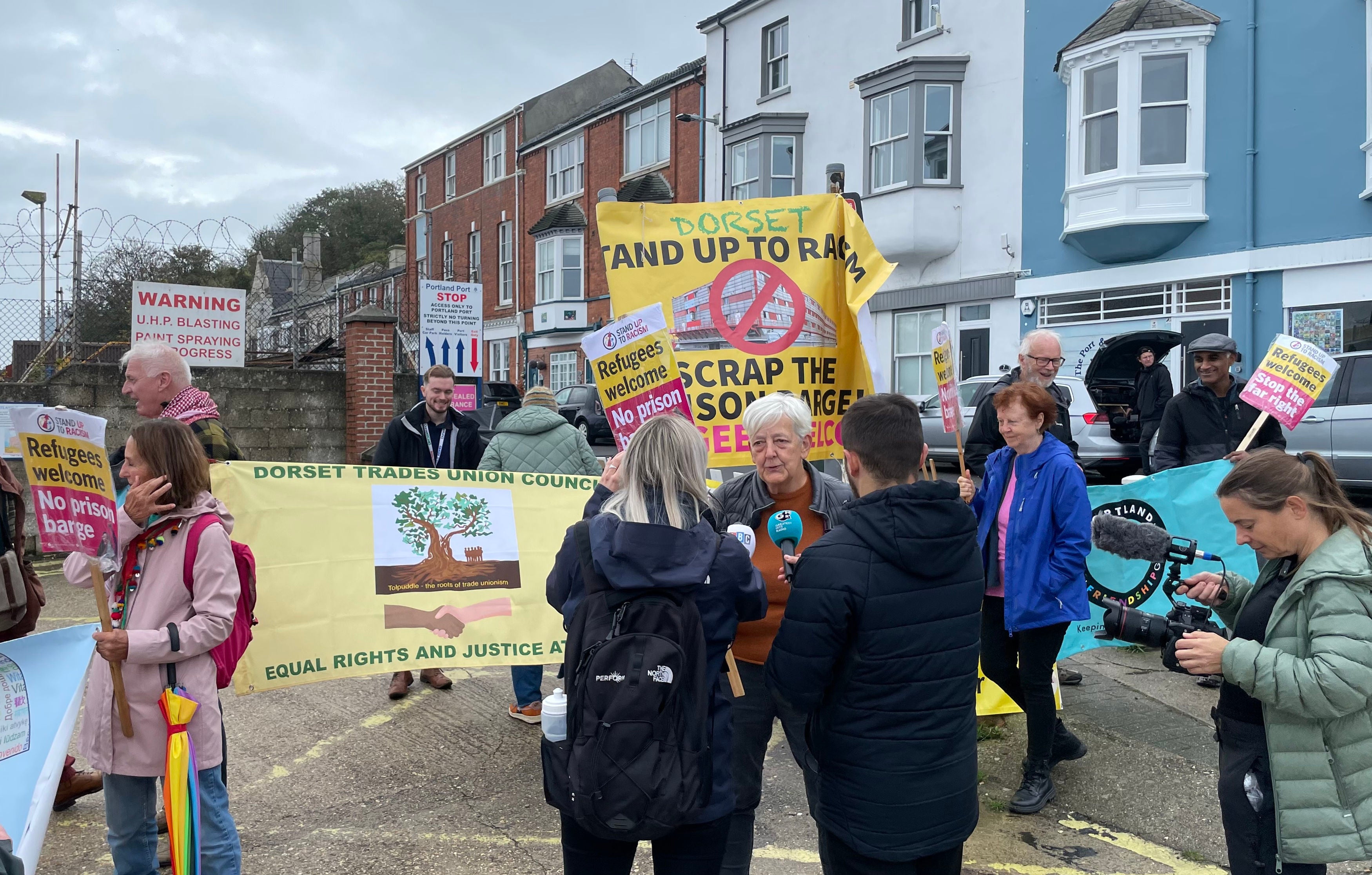 Candy Udwin, of Stand Up Against Racism Dorset, speaks to the media during a protest near the Bibby Stockholm accommodation barge at Portland Port in Dorset.