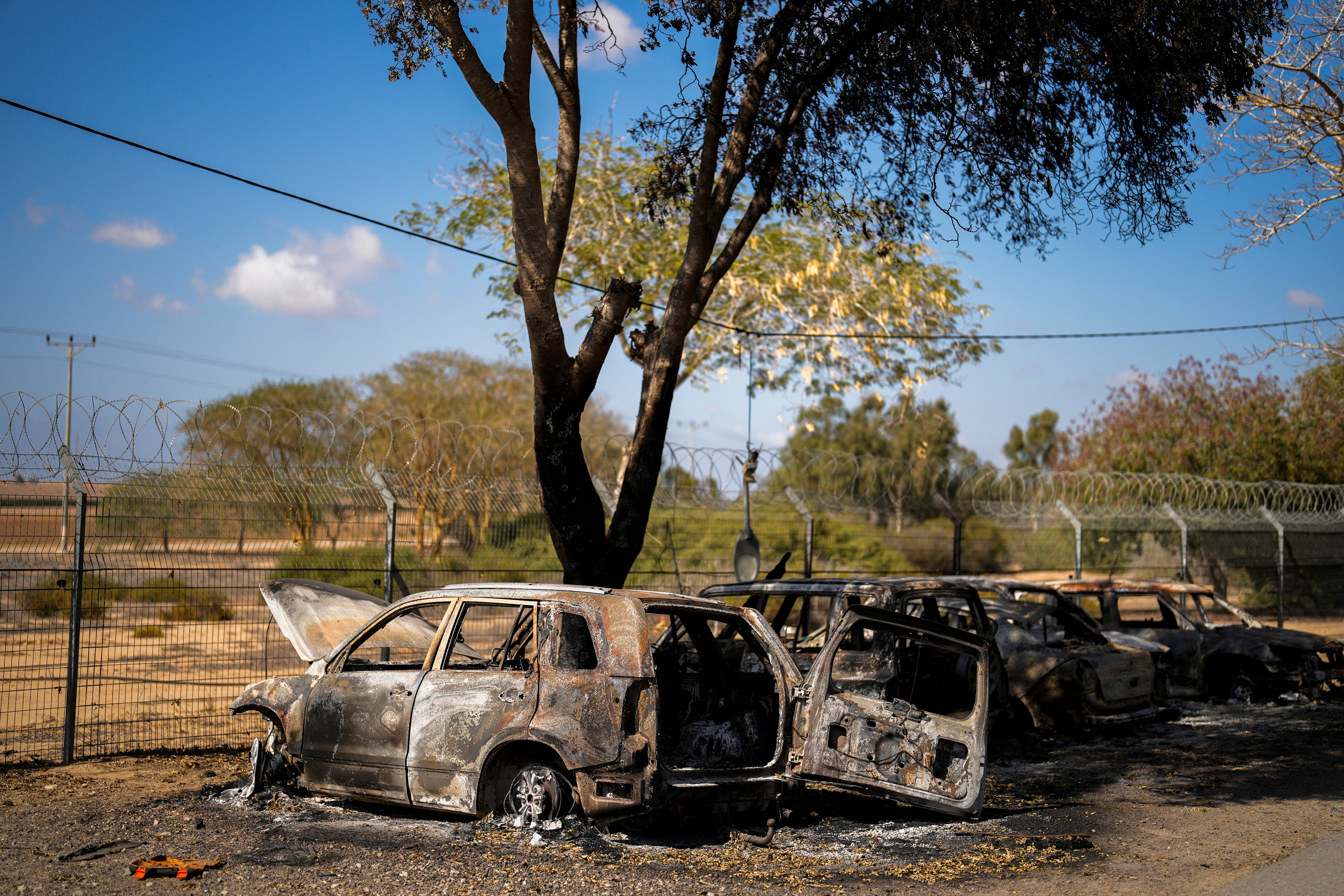 Burned cars next to homes that came under attack during a massive Hamas invasion into Kibbutz Nir Oz