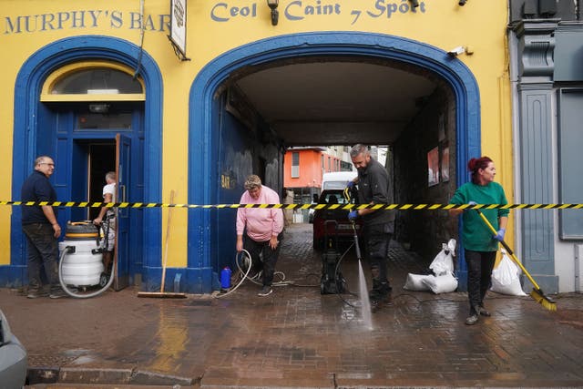 The clean up gets underway on Main Street in Midleton, Co Cork, after extensive damage caused by flooding following Storm Babet (PA)