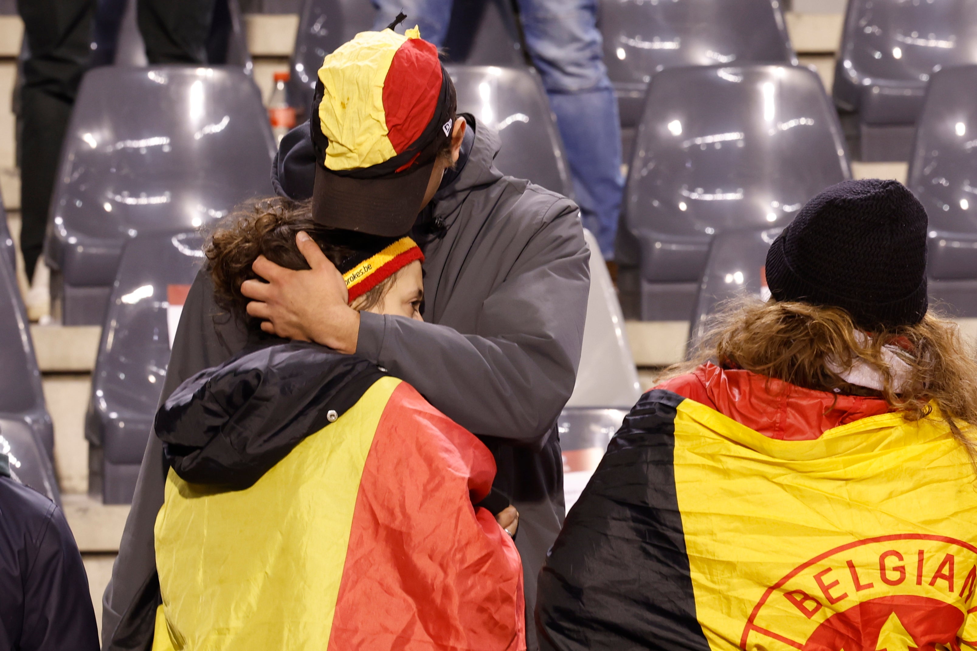 A supporter is comforted on the stands after suspension of the Euro 2024 group F qualifying soccer match between Belgium and Sweden at the King Baudouin Stadium in Brussels, Monday, Oct. 16, 2023