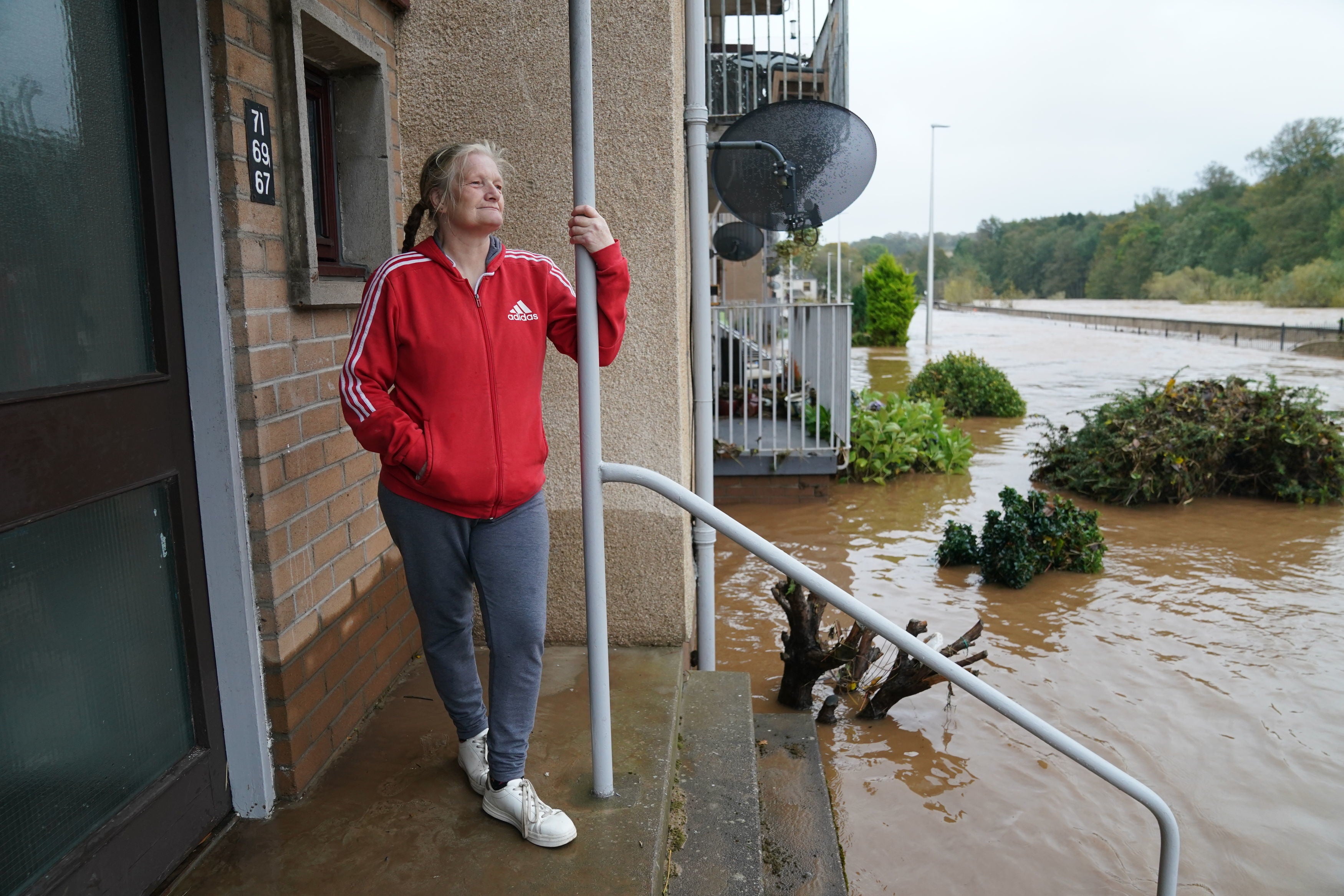 A woman looks out at flood water outside her home in Brechin, Scotland, after Storm Babet battered the town overnight