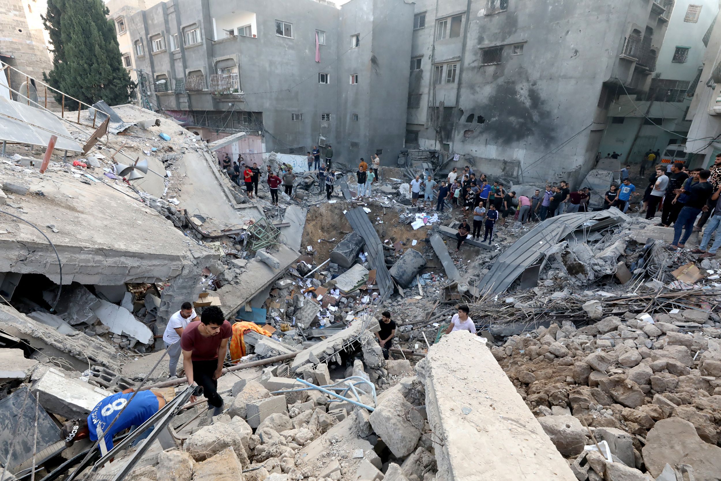 Palestinians search the destroyed annex of the Greek Orthodox Saint Porphyrius Church