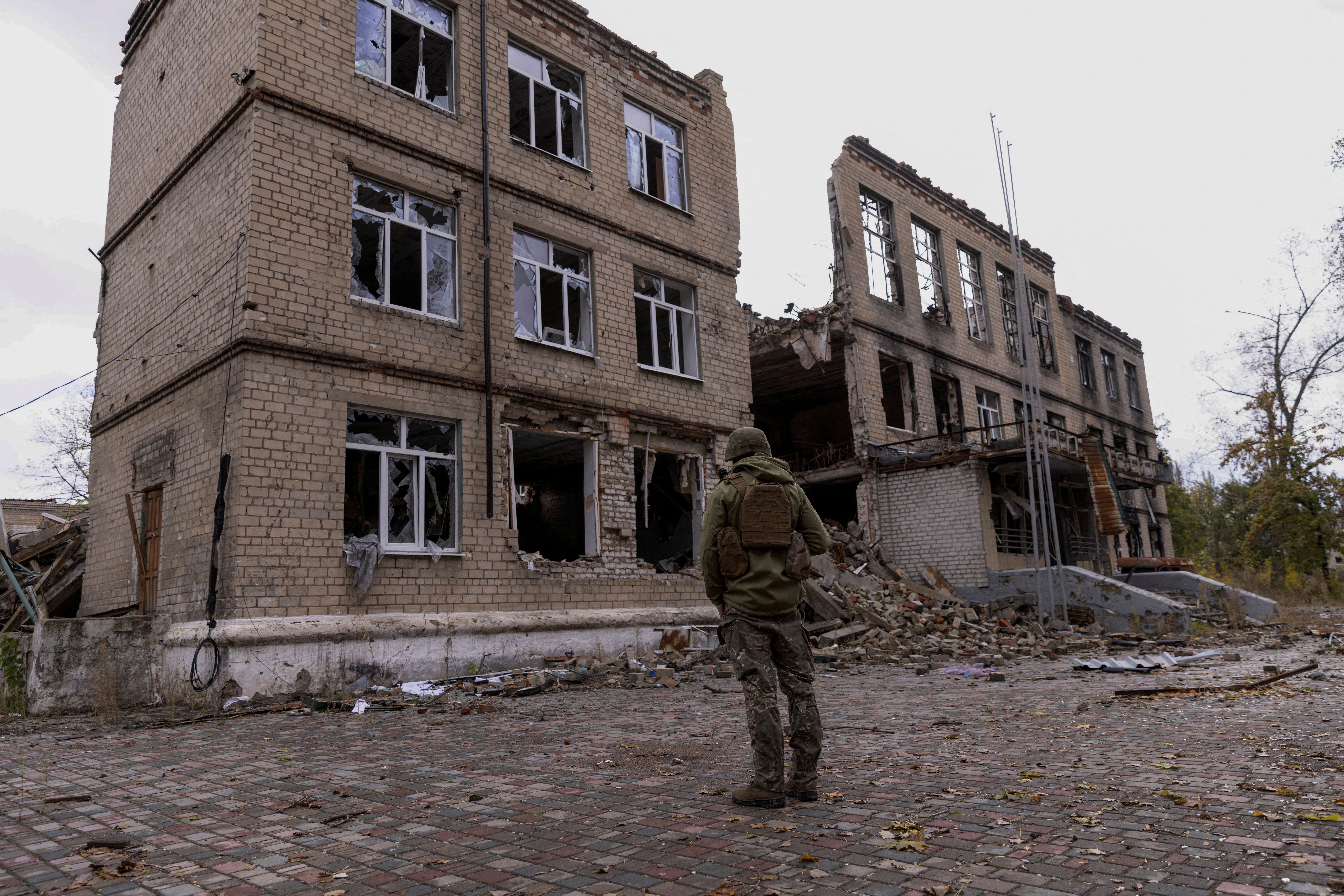 A police officer stands in front of a damaged building, amid Russia's attack on Ukraine, in the town of Avdiivka, Donetsk region, Ukraine