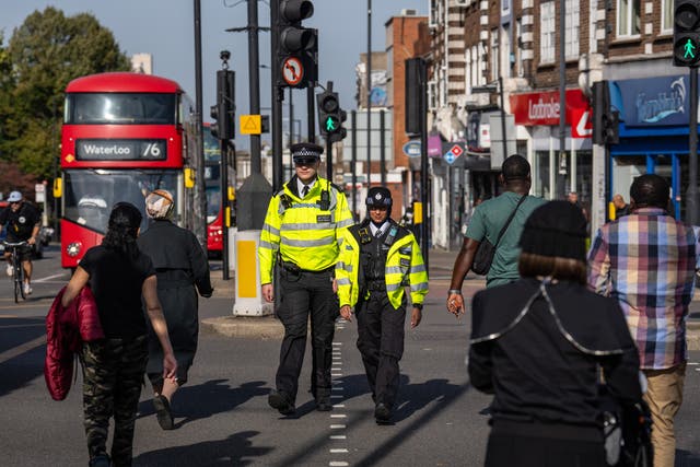 <p>Police officers patrol through Stamford Hill, an area of London with a large Jewish community, in October </p>