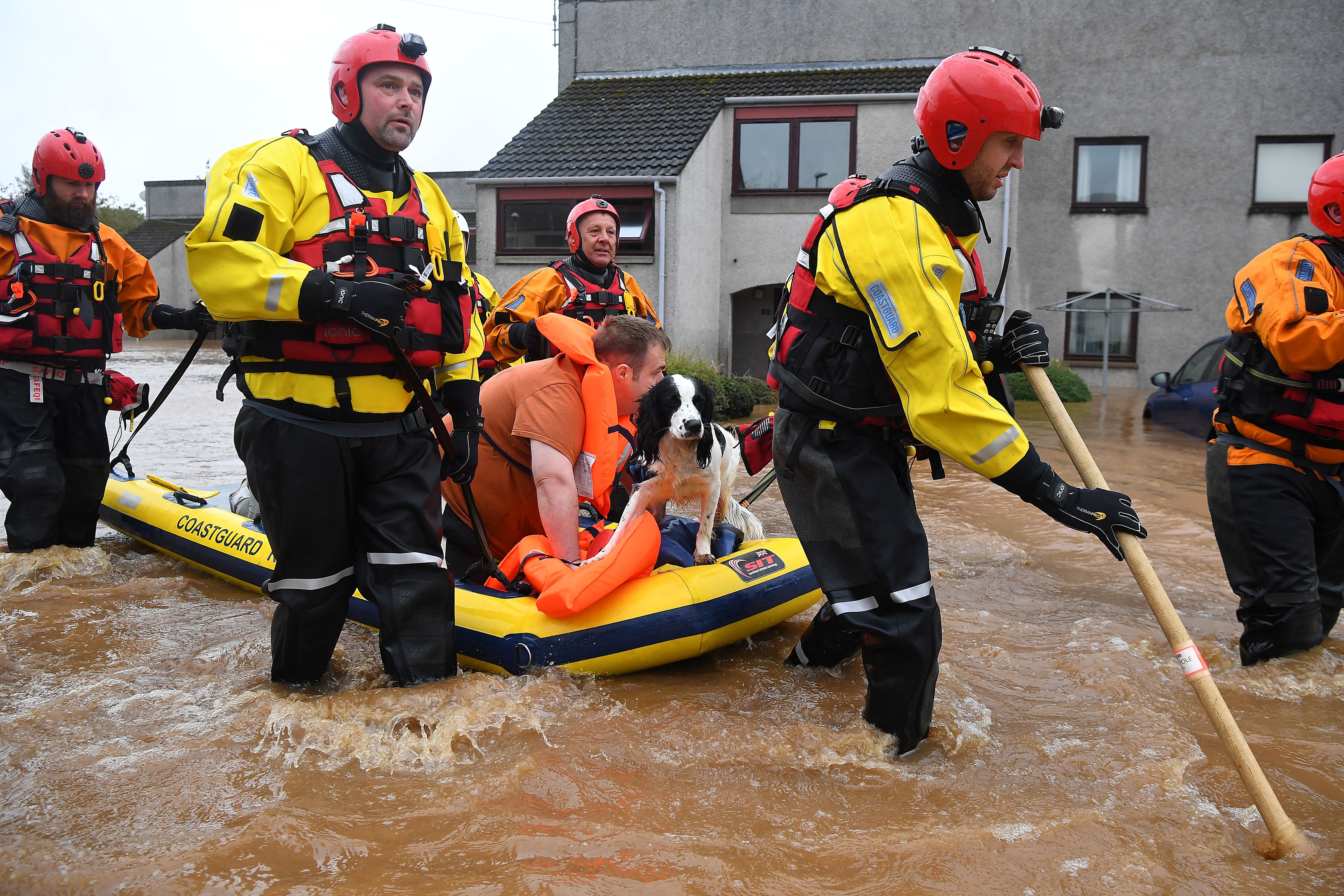 <p>A couple and their dog are rescued by a Coastguard team from a flooded street in Brechin, northeast Scotland on Friday </p>
