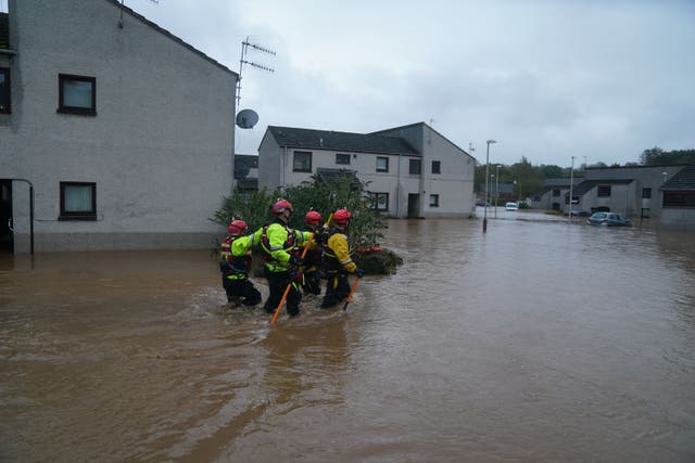 Emergency workers wade through flood water in Brechin, Scotland (Andrew Milligan/PA)