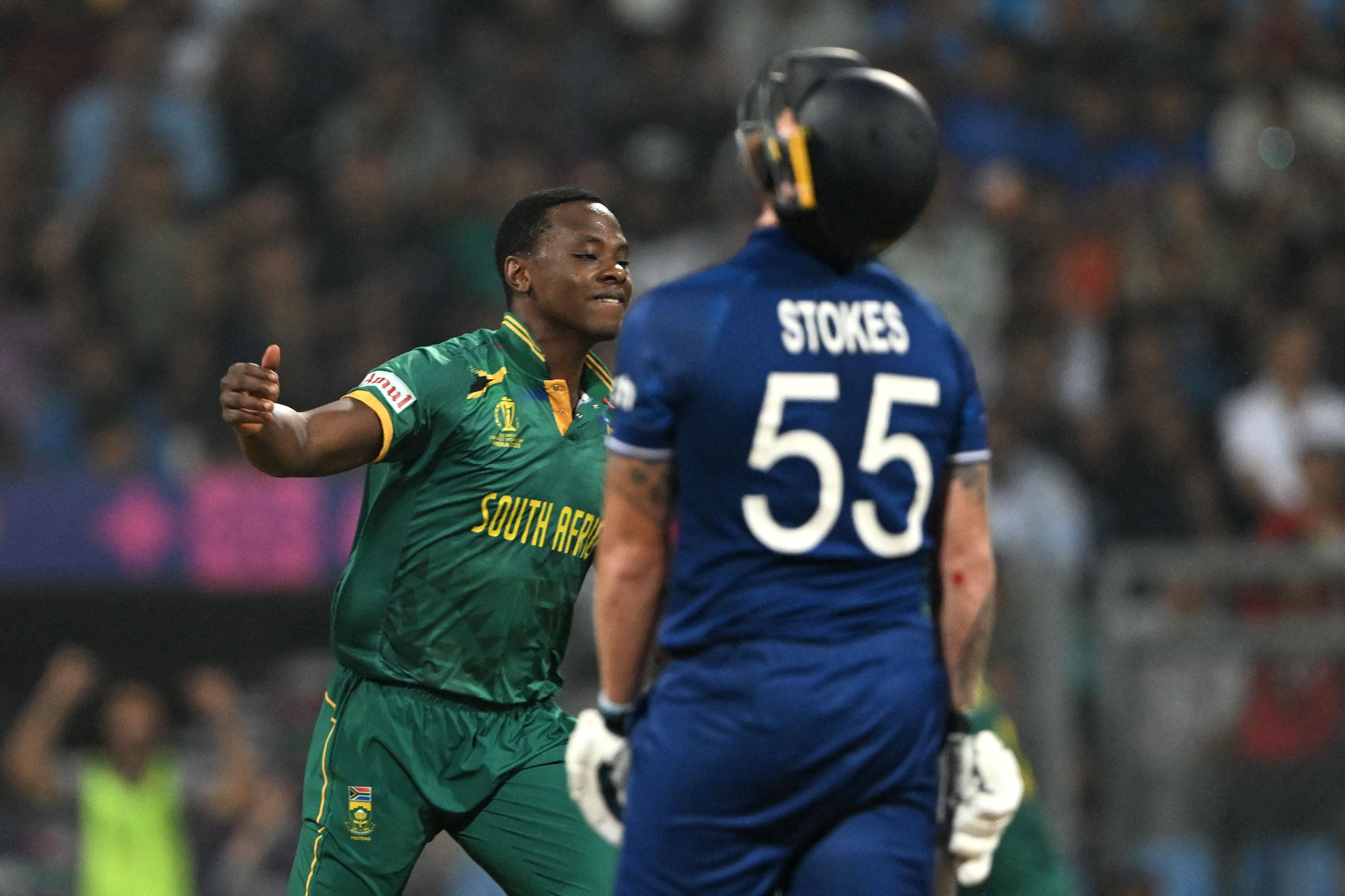 South Africa's Kagiso Rabada celebrates after taking the wicket of England's Ben Stokes (R) during the 2023 ICC Men's Cricket World Cup one-day international (ODI) match between England and South Africa