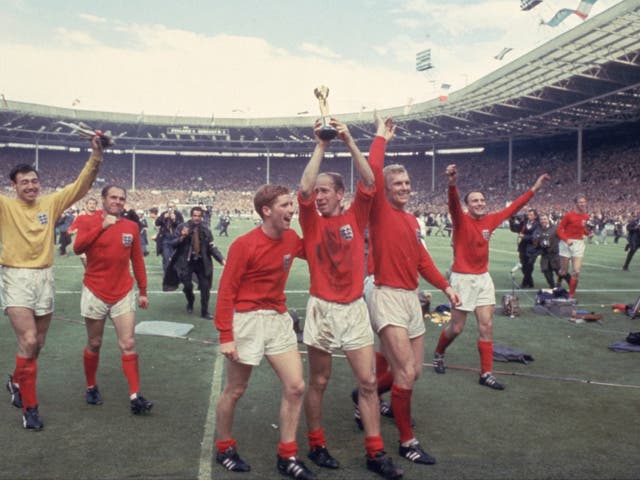 <p>Bobby Charlton (centre) celebrates with the World Cup at Wembley on 30 July 1966 </p>