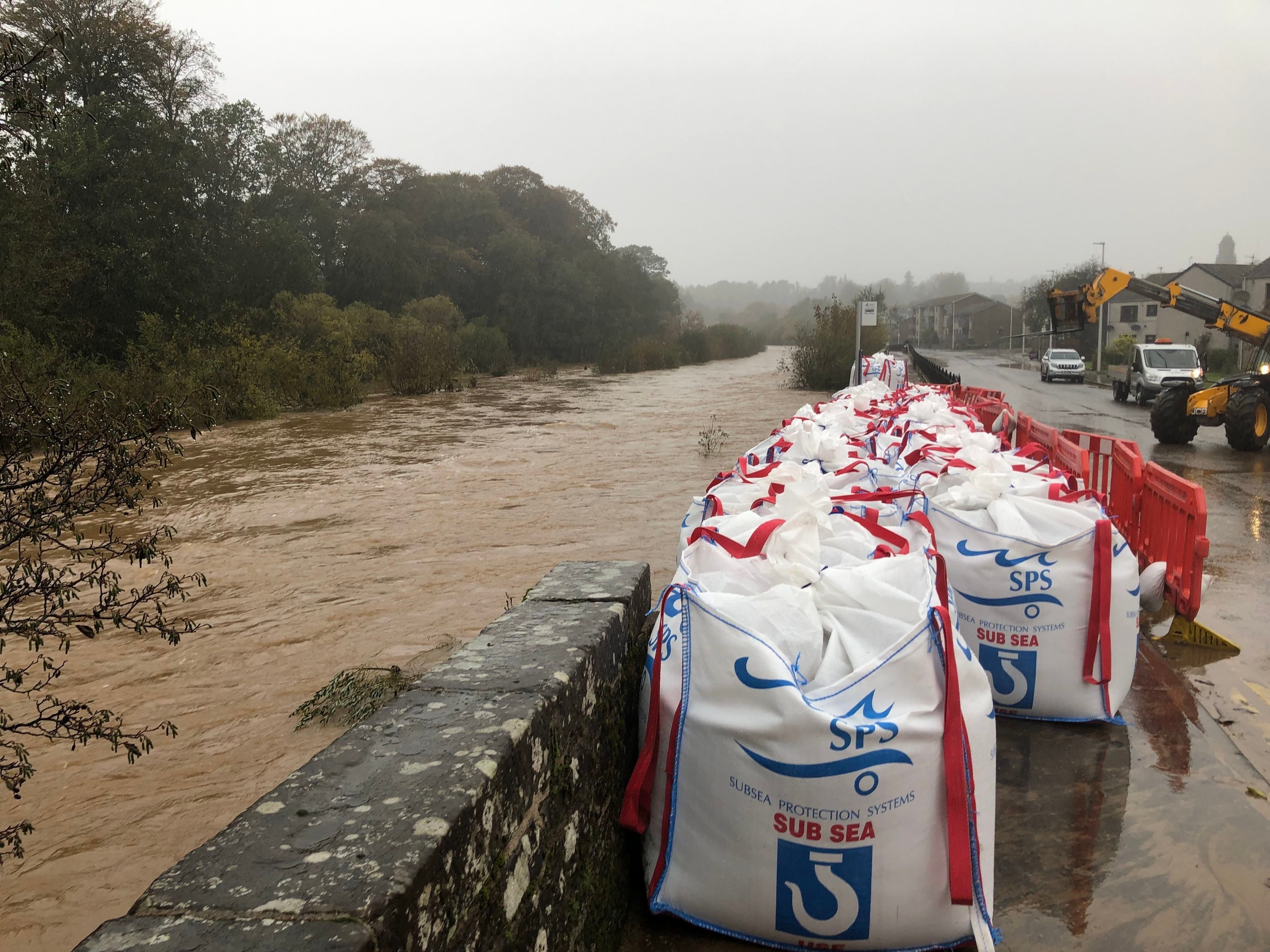 Sandbags are placed alongside a collapsed river wall on River Street in Brechin as Storm Babet batters the country