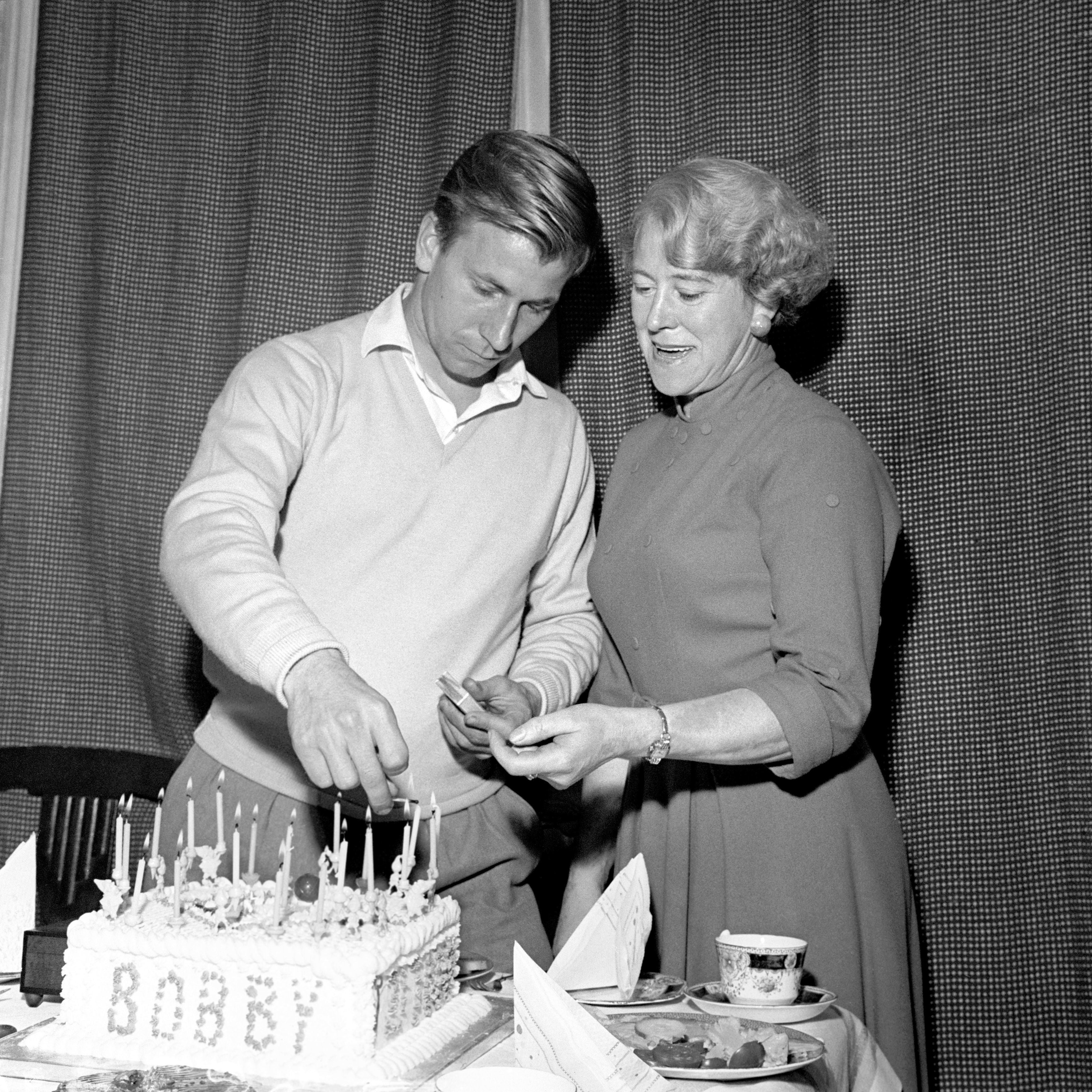 Aided by his mother, Betty, Charlton lights the candles on his 21st birthday cake at his home at Ashington