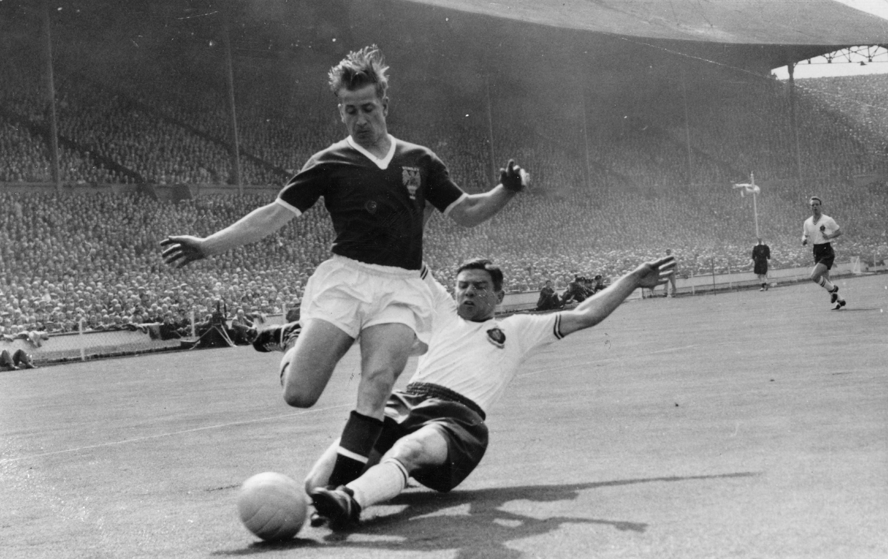 Charlton is tackled by Tommy Banks during the 1958 FA Cup final, which Bolton won 2-0