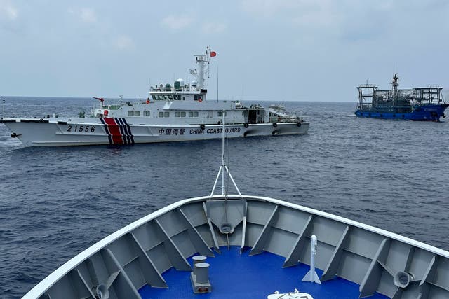 <p>A Chinese coast guard ship, left, with a Chinese militia vessel, right, blocks Philippine coast guard ship, ‘BRP Sindangan’, as it tried to head towards Second Thomas Shoal at the disputed South China Sea during rotation and resupply mission </p>