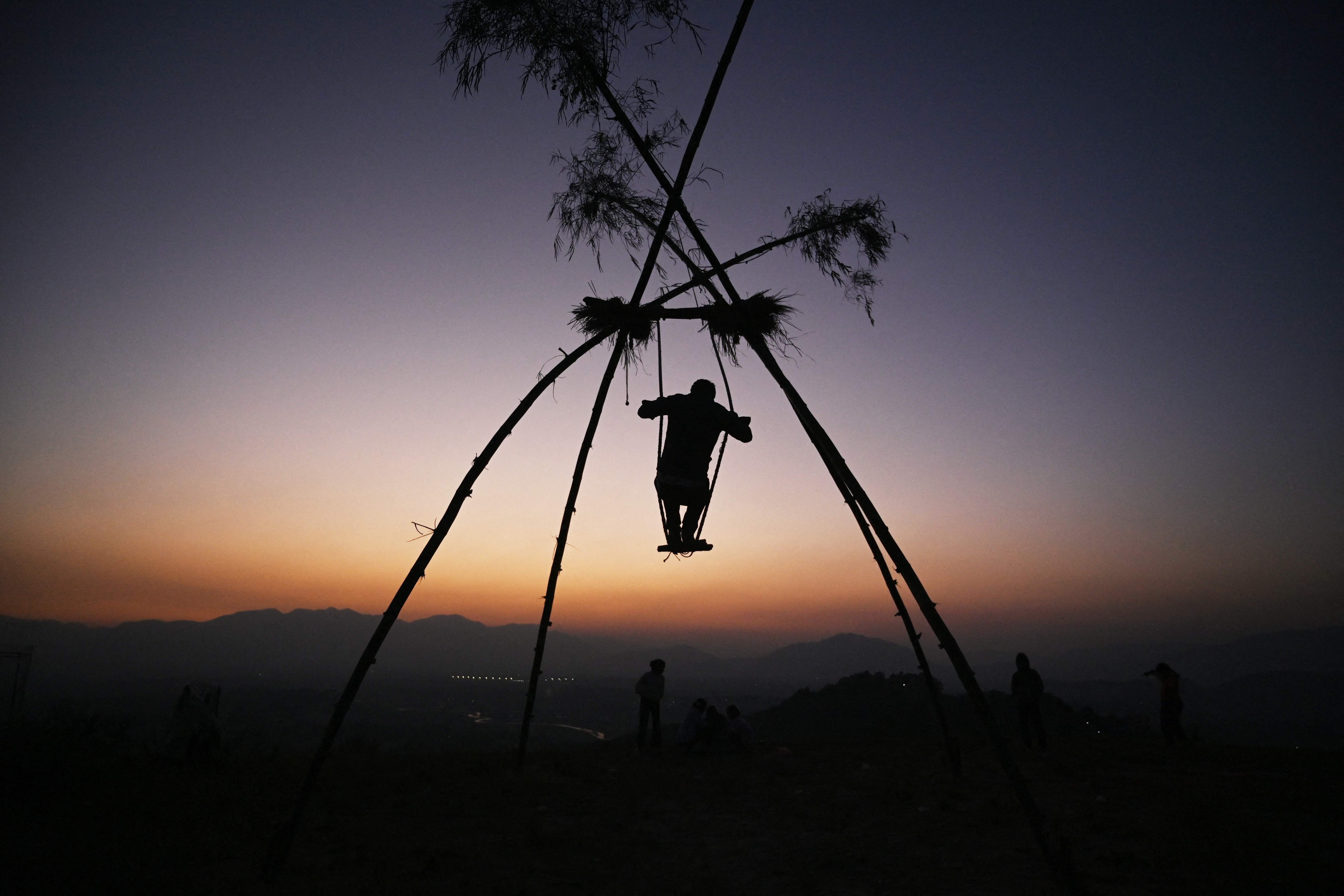 A boy sways on a swing traditionally called the 'Dashain Ping' on the occasion of the Nepali Hindu festival 'Dashain'
