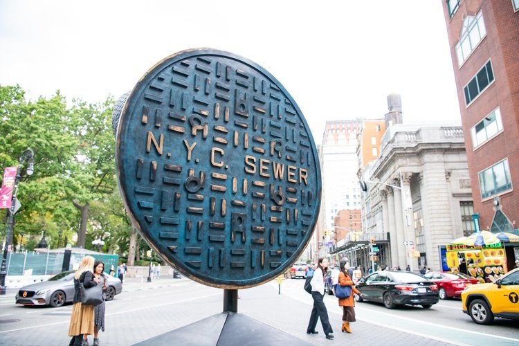 The flip side of the statue depicts a sewer manhole