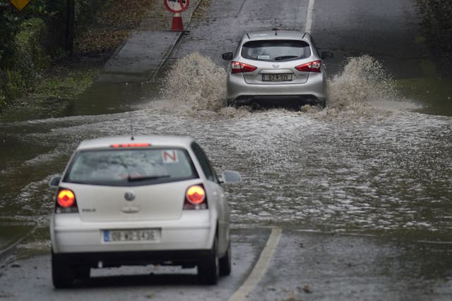 A car is driven through a flooded road in Faithlegg, Co. Waterford, Ireland, following Storm Babet (Niall Carson/PA)