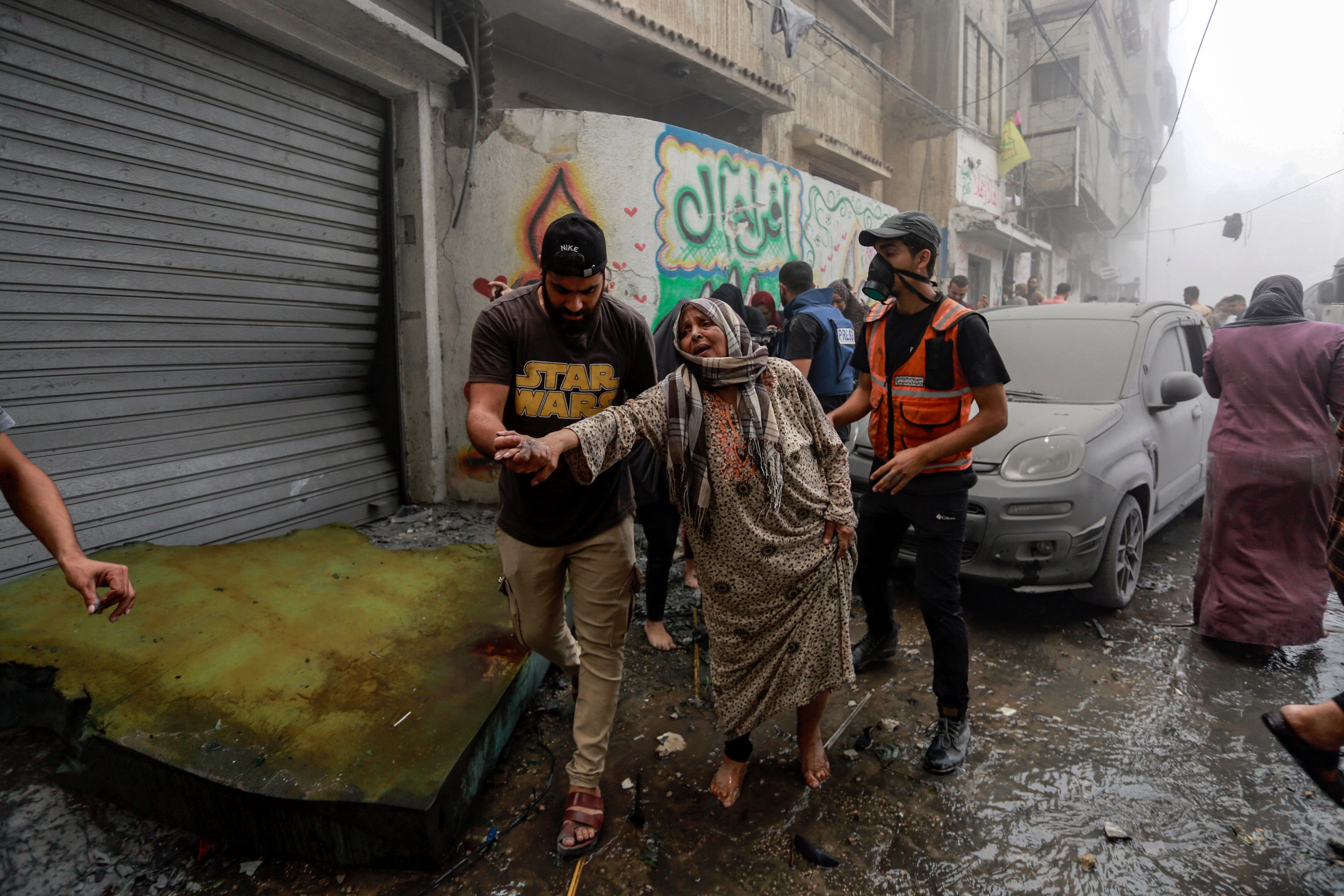 People help evacuate a Palestinian woman following Israeli airstrikes that targeted her neighbourhood in Gaza City.