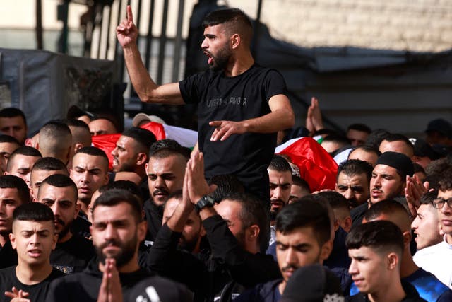 <p>Mourners rally on the way to the funeral in the West Bank</p>
