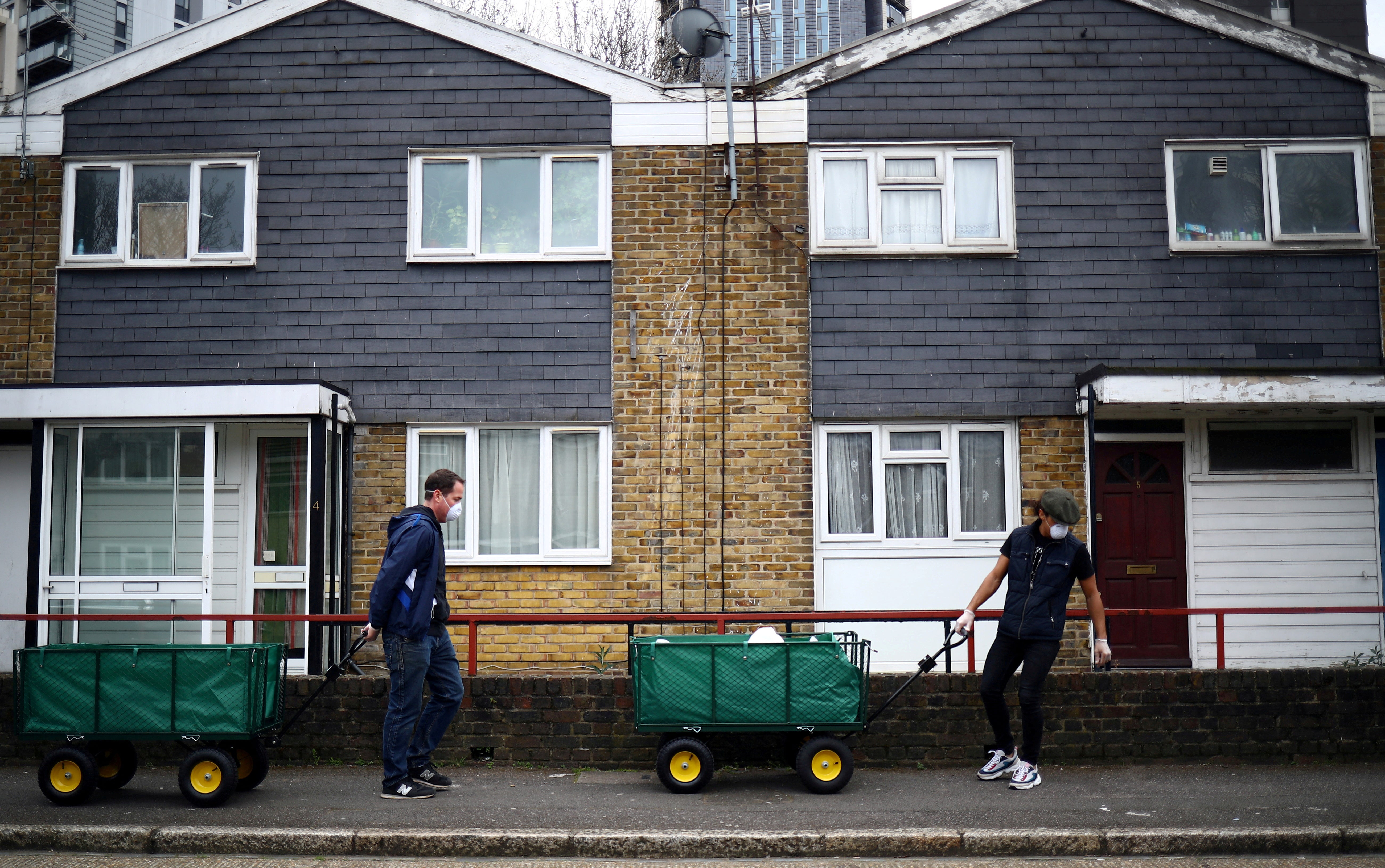 Volunteers cart food donations from a local food bank through the Carpenters Estate in Stratford in east London