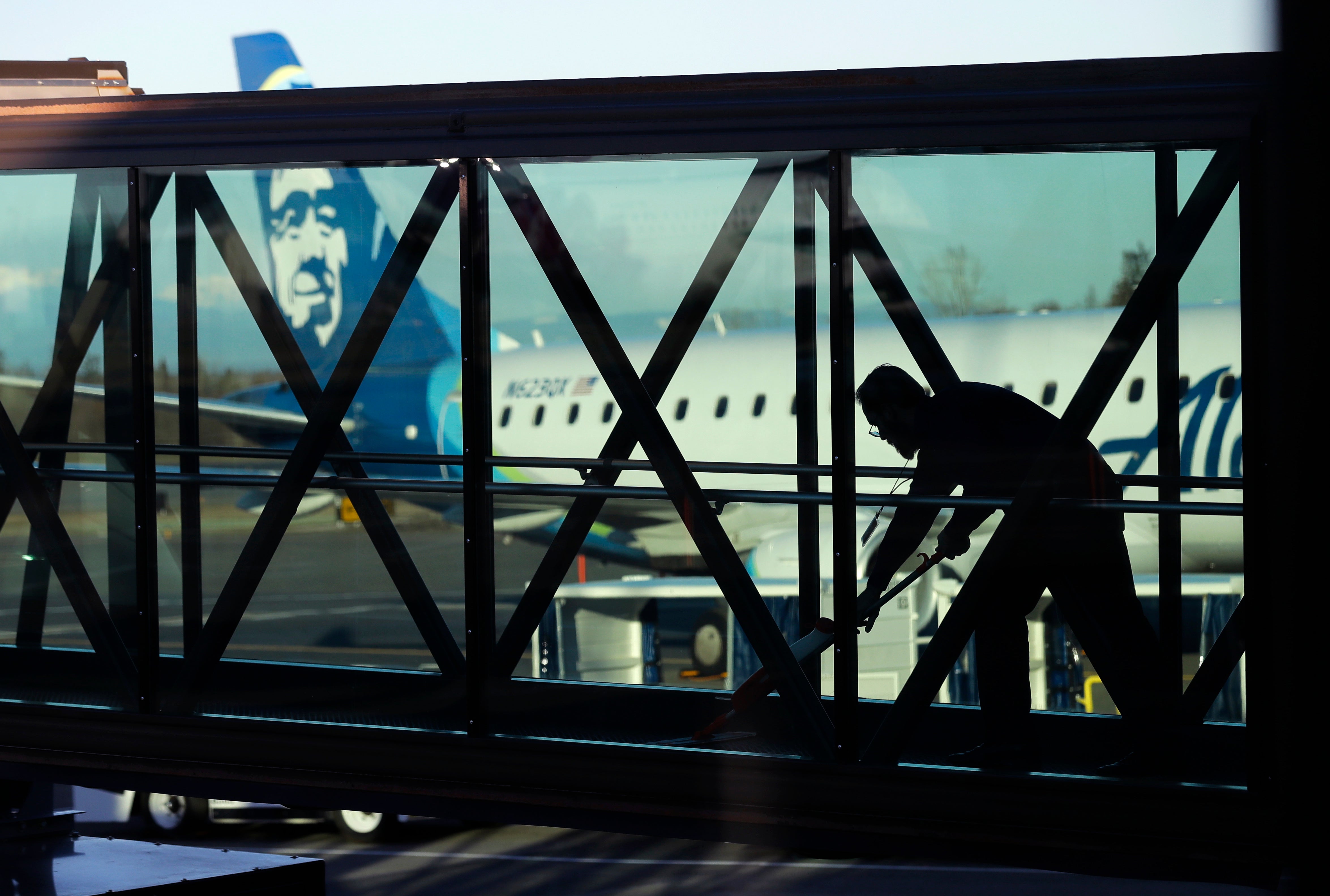 <p>A worker cleans a jet bridge at Paine Field in Everett, Washington, before passengers board an Alaska Airlines flight </p>