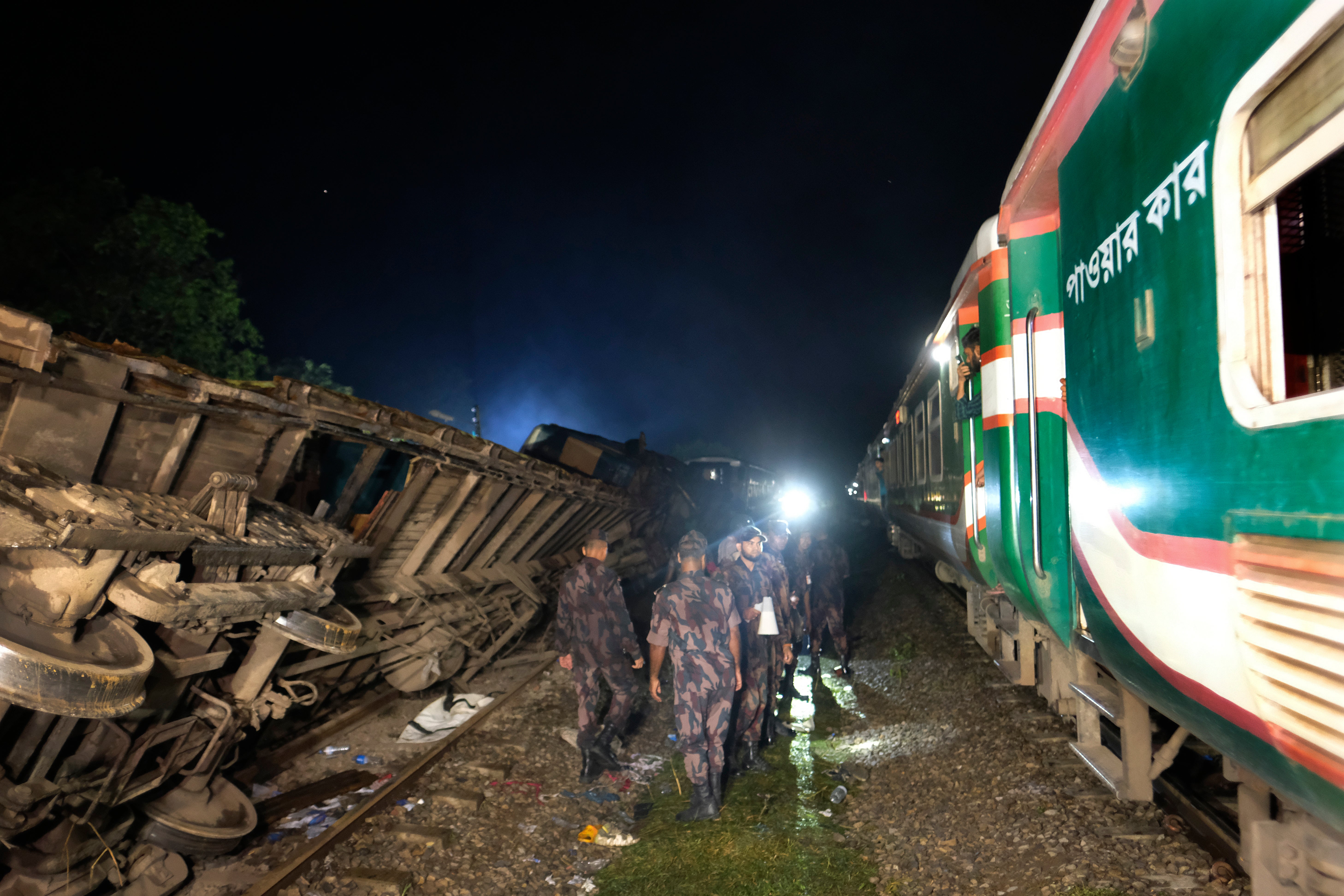 Policemen stand guard at the site of an accident where a cargo train hit a passenger train at Bhairab, Kishoreganj district, Bangladesh, Monday, 23 October 2023, leaving more than dozen people dead and scores injured