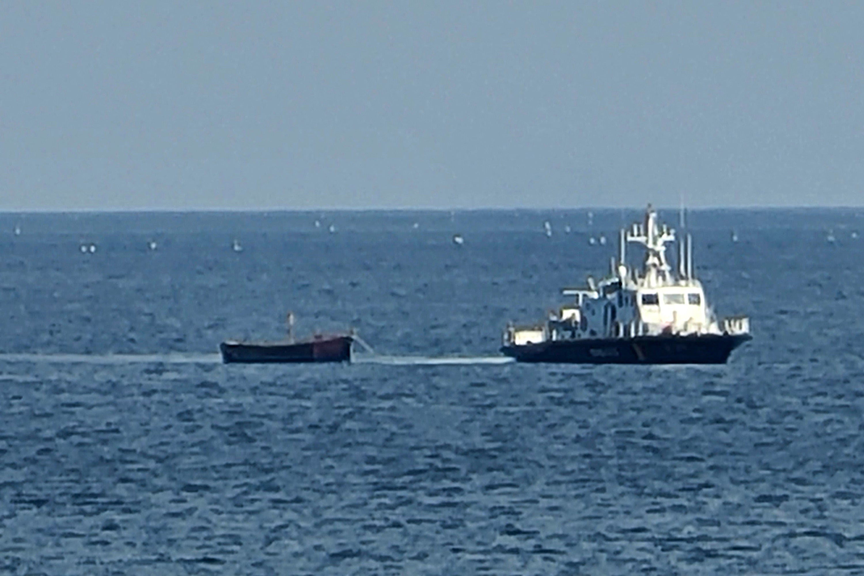 A small wooden boat that was carrying the defectors is towed into a port in Yangyang, South Korea