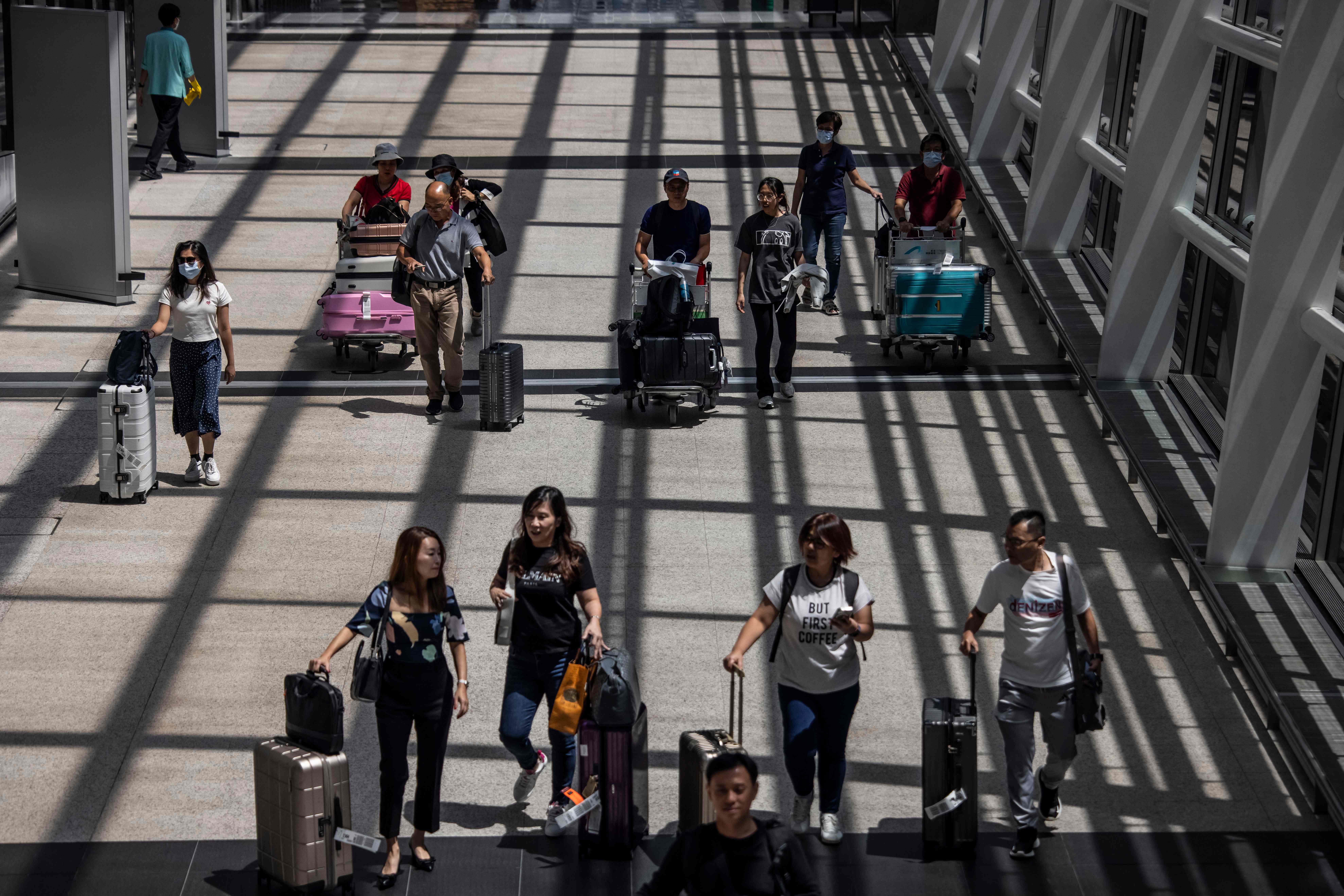 Passengers walk through Hong Kong International Airport on July 6, 2023.
