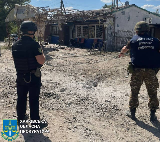 <p>In this handout photograph taken and released by the Office of the Prosecutor General of Ukraine on 26 August 2023, war crime prosecutors work at the site of a shelling in the village of Podoly near Kupiansk, Kharkiv region</p>