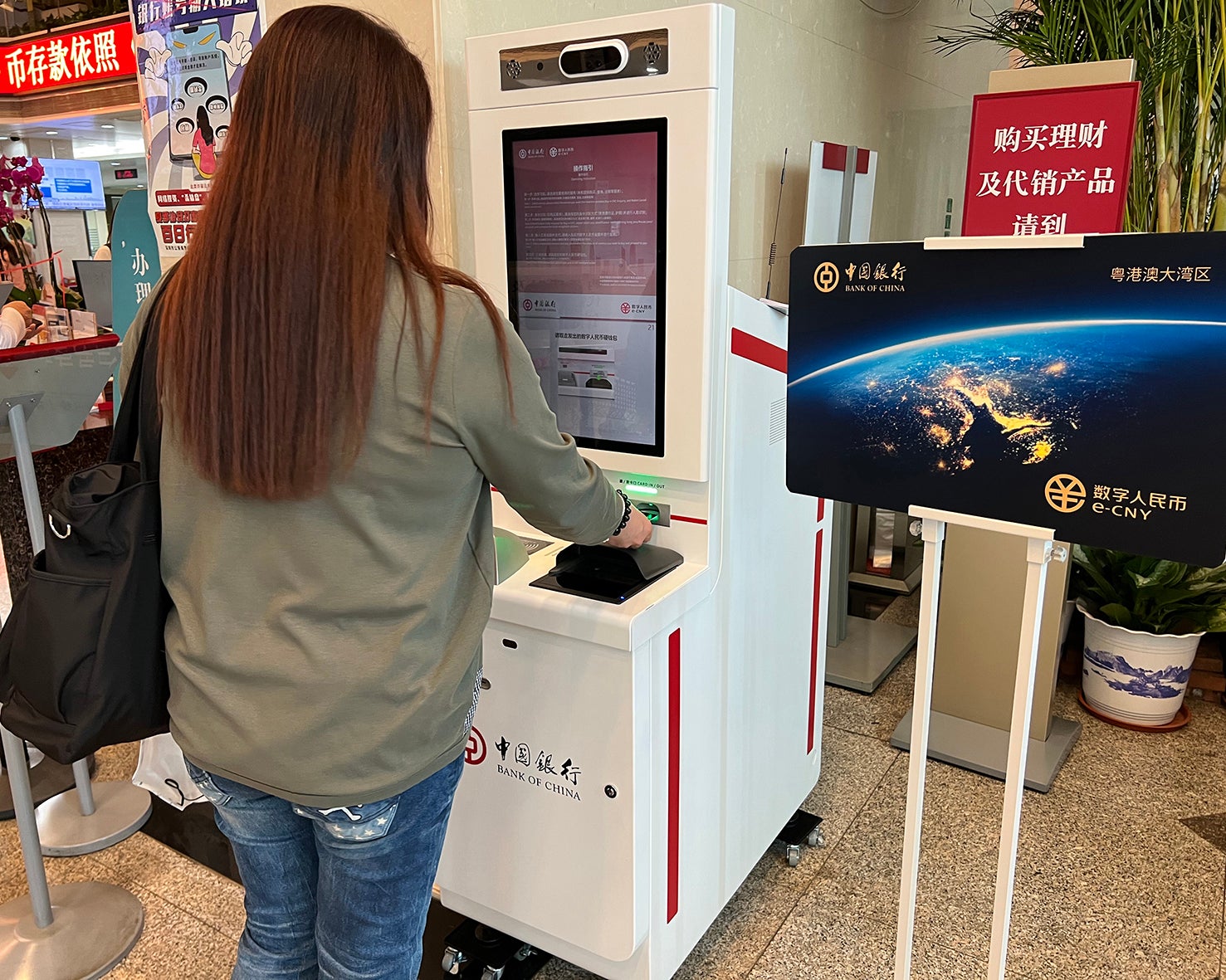 A customer registers for an e-CNY wallet card through a self-service machine at a branch of Bank of China in Shenzhen, Guangdong province, in February