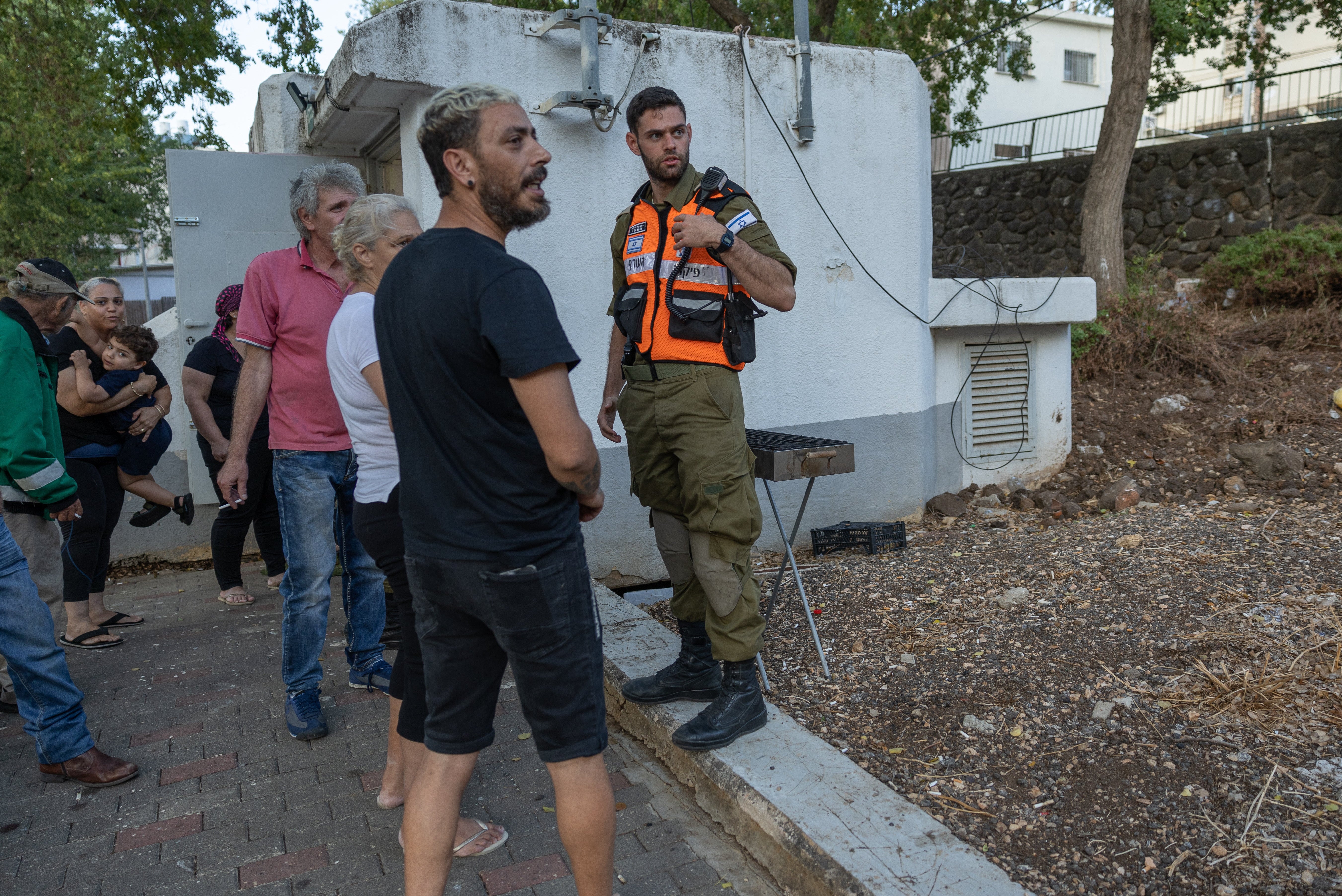 Families emerge from their bomb shelter in Kiryat Shmona to be evacuated to Tel Aviv