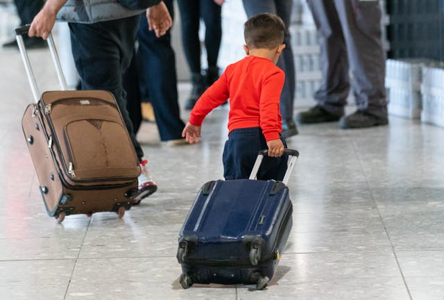 <p>A young boy pulling a suitcase as refugees arrive from Afghanistan at Heathrow Airport, London.</p>