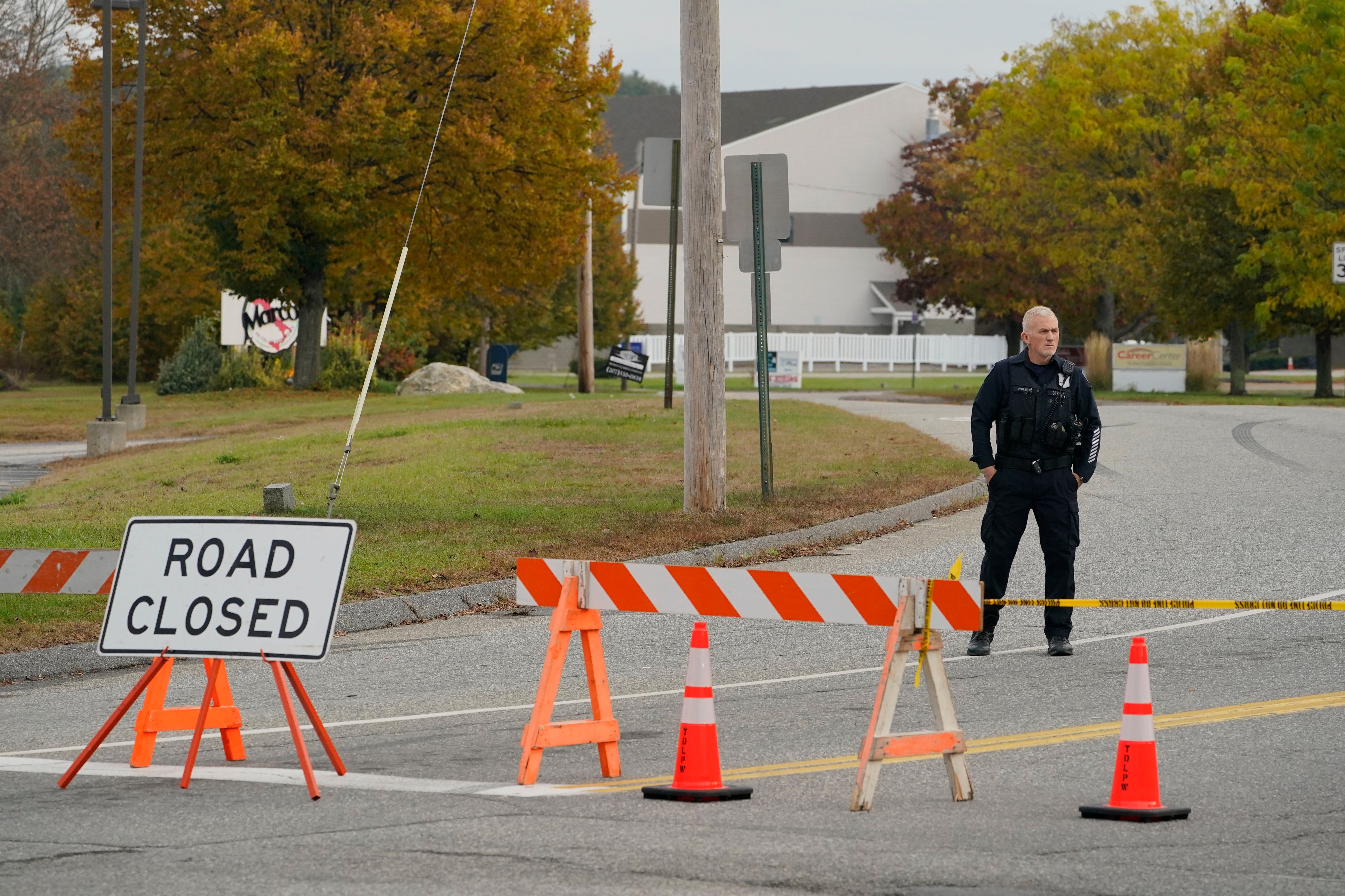 A police officer stands at a road closure near the bowling alley