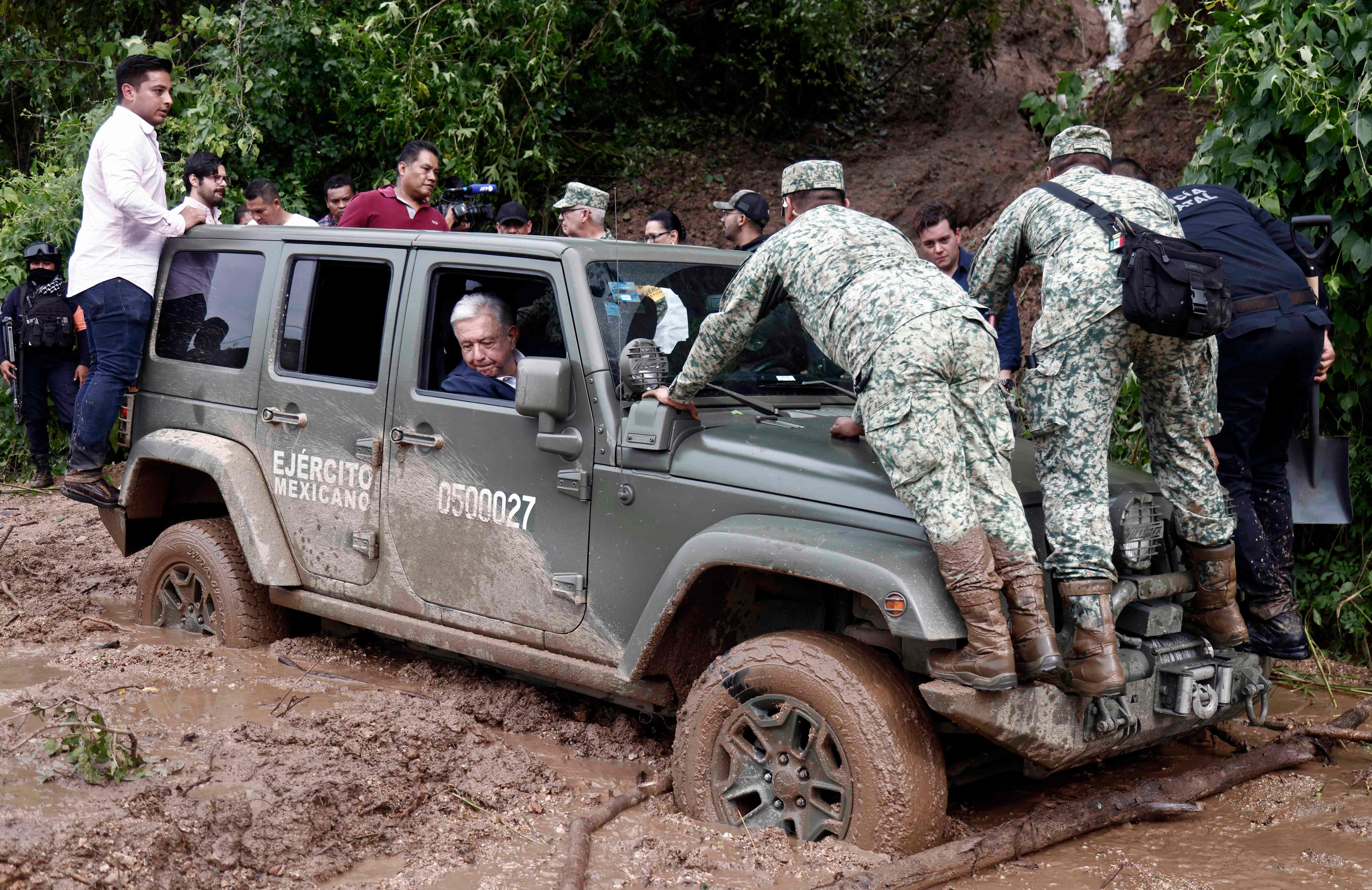 Mexican President Andres Manuel Lopez Obrador’s vehicle is stuck in mud during a visit to the Kilometro 42 community, near Acapulco, Guerrero State, Mexico, after the passage of Hurricane Otis, on October 25, 2023