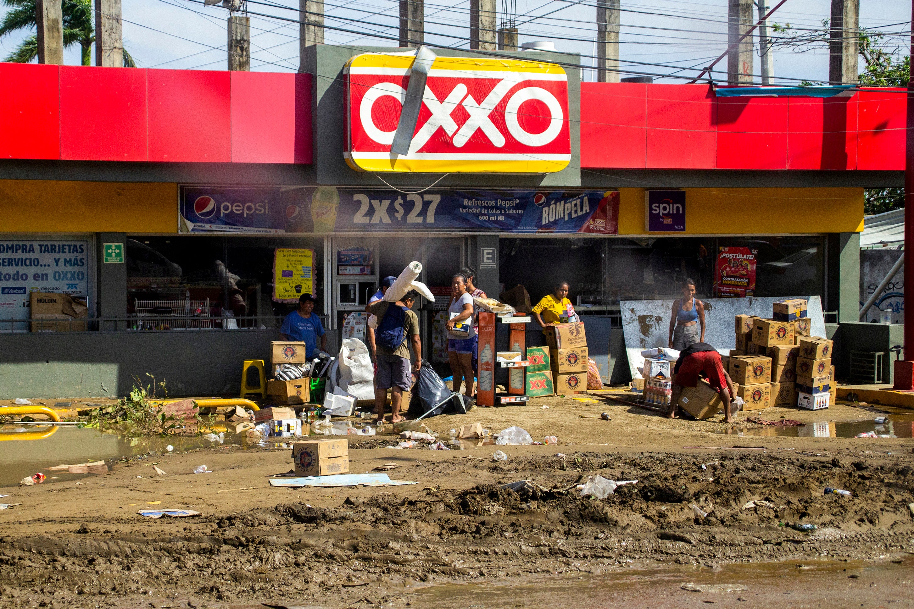 People carry products from a looted store after hurricane Otis hit Acapulco on October 26, 2023 in Acapulco, Mexico