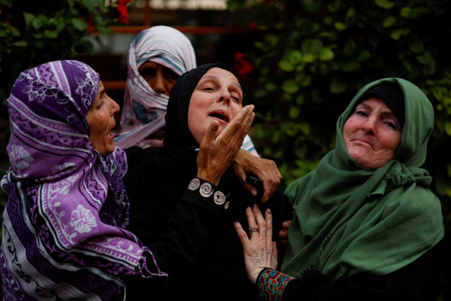 <p>Palestinians mourn during the funeral of Palestinian nurse Haniyeh Qudih, who was killed in an Israeli strike, as the conflict between Israel and Palestinian Islamist group Hamas continues</p>