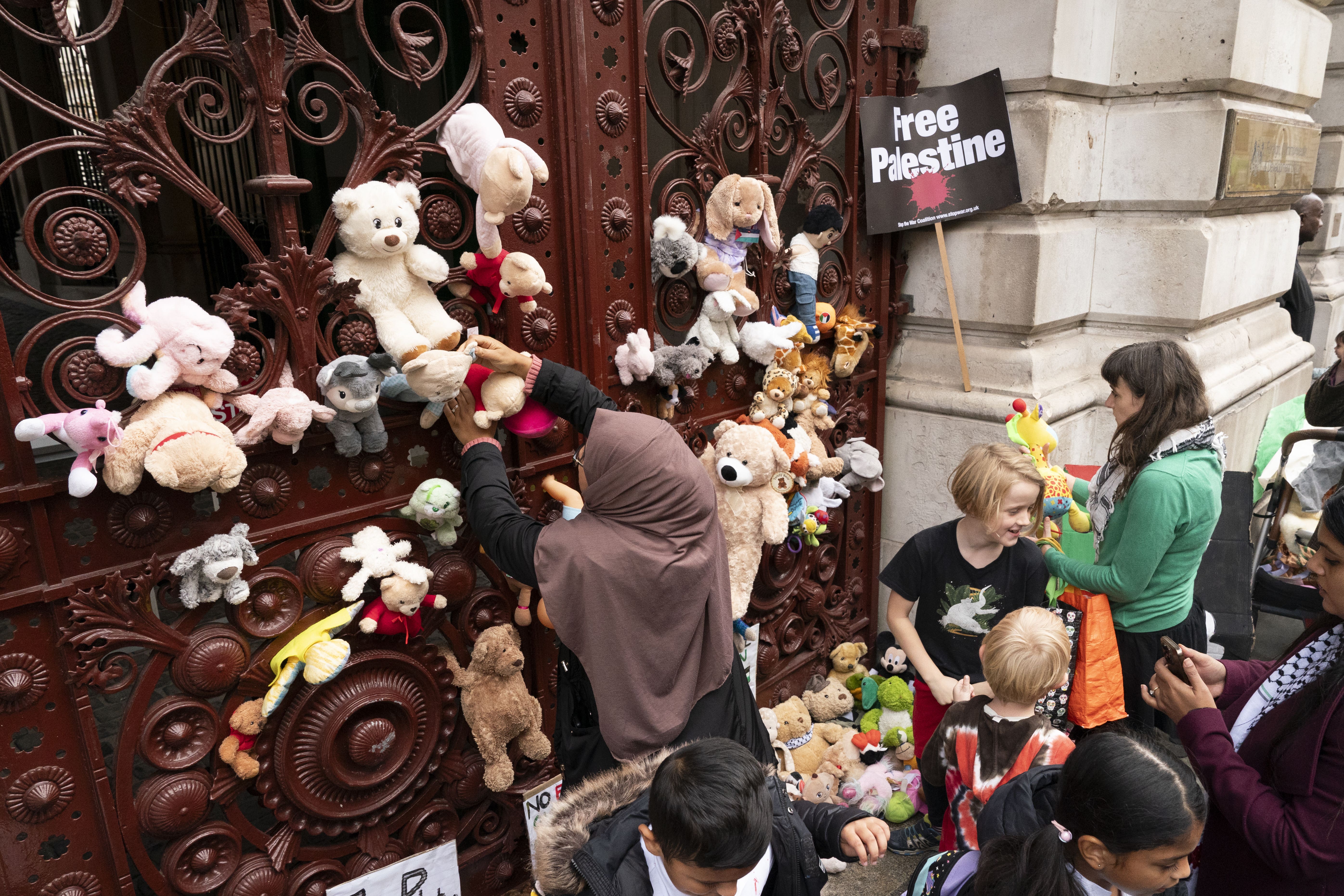 Parents and children lay cuddly toys across the entrance to the Foreign Office in London