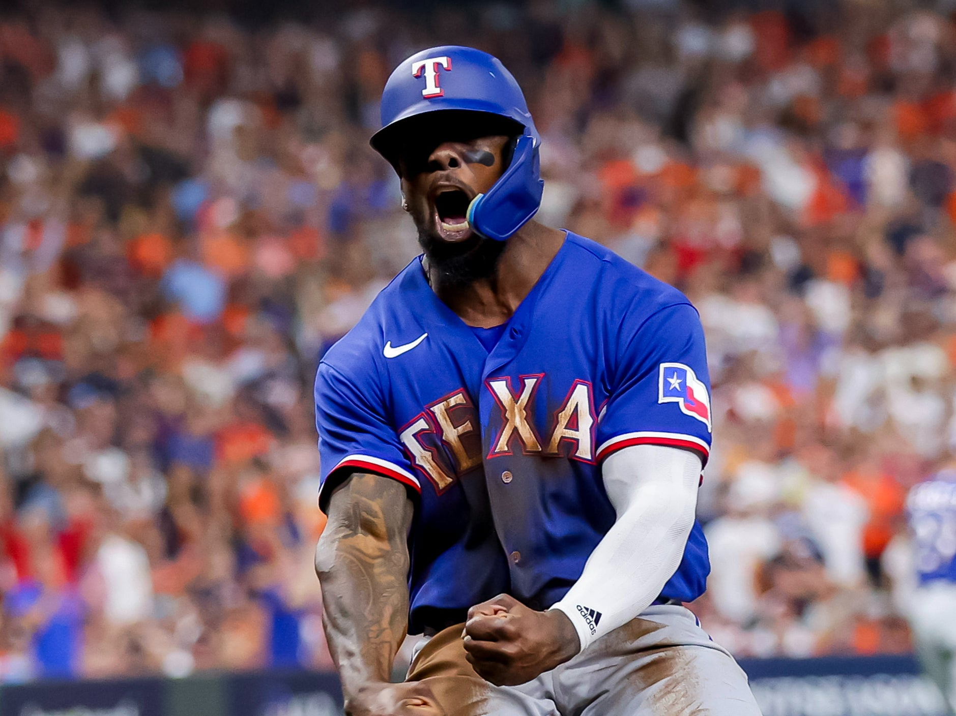 Texas Rangers right fielder Adolis Garcia reacts after scoring against the Houston Astros